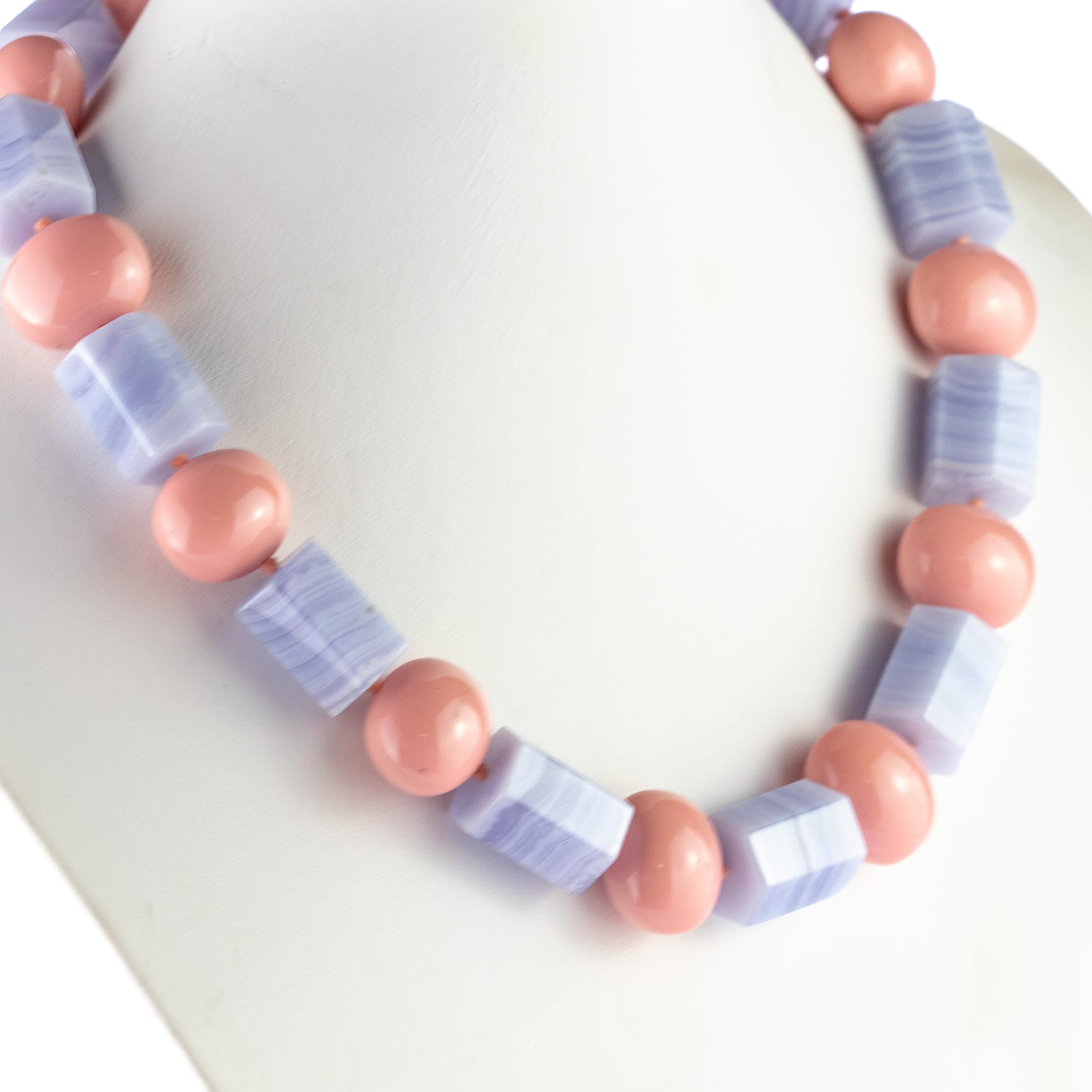 Questa magnifica collana è realizzata a mano in calcedonio e resina rosa. Queste perline hanno forme luminose e intagliate con colori rosa brillante e viola chiaro che creano un'illusione di gamma di colori.

Questo gioiello si ispira alla forza e