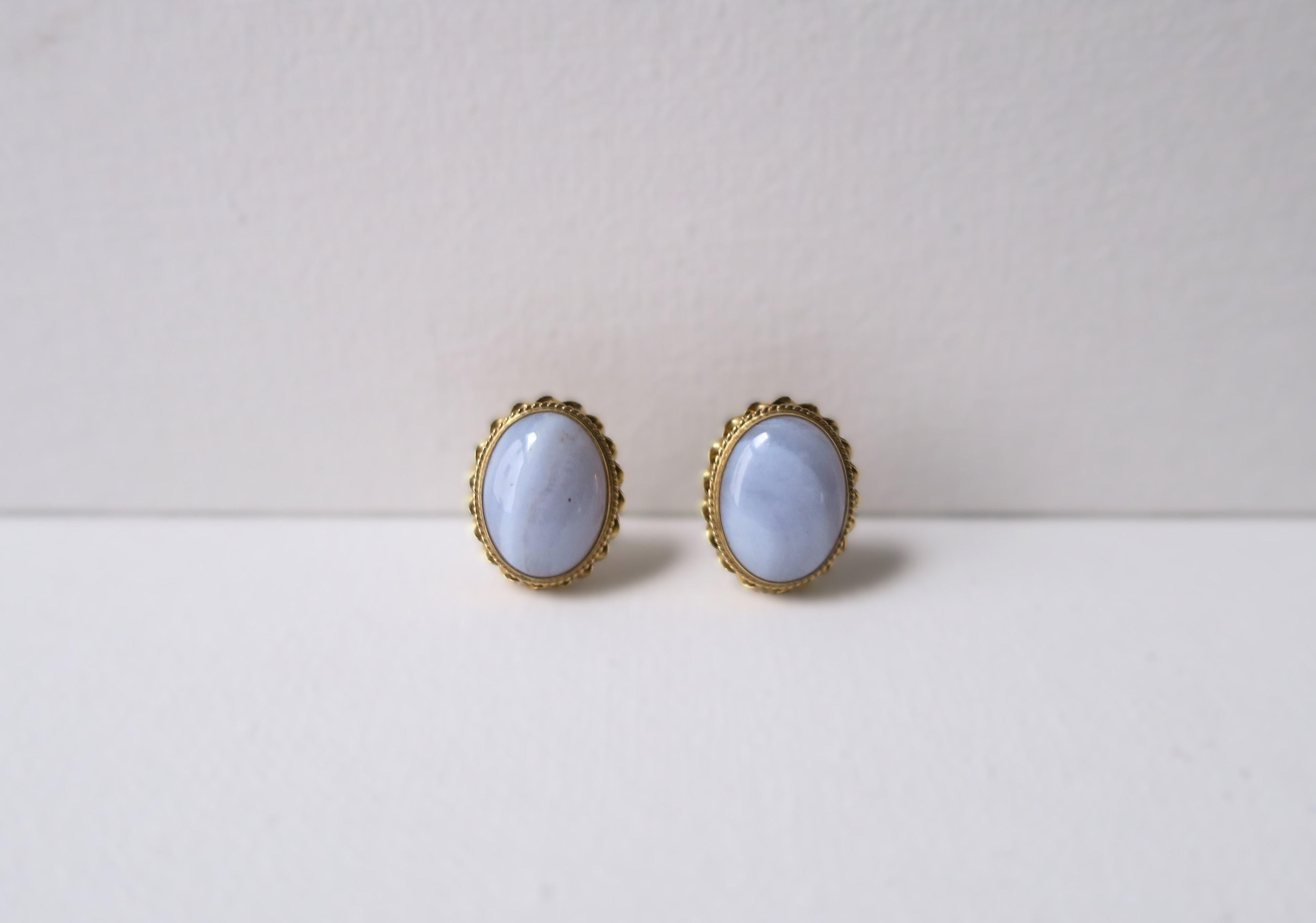 A chic pair of vintage oval chalcedony quartz and 14-karat yellow gold earrings, circa mid-20th century. Chalcedony is oval in shape with twisted 14-karat gold border. A great pair for everyday wear. Each earring has maker's mark 