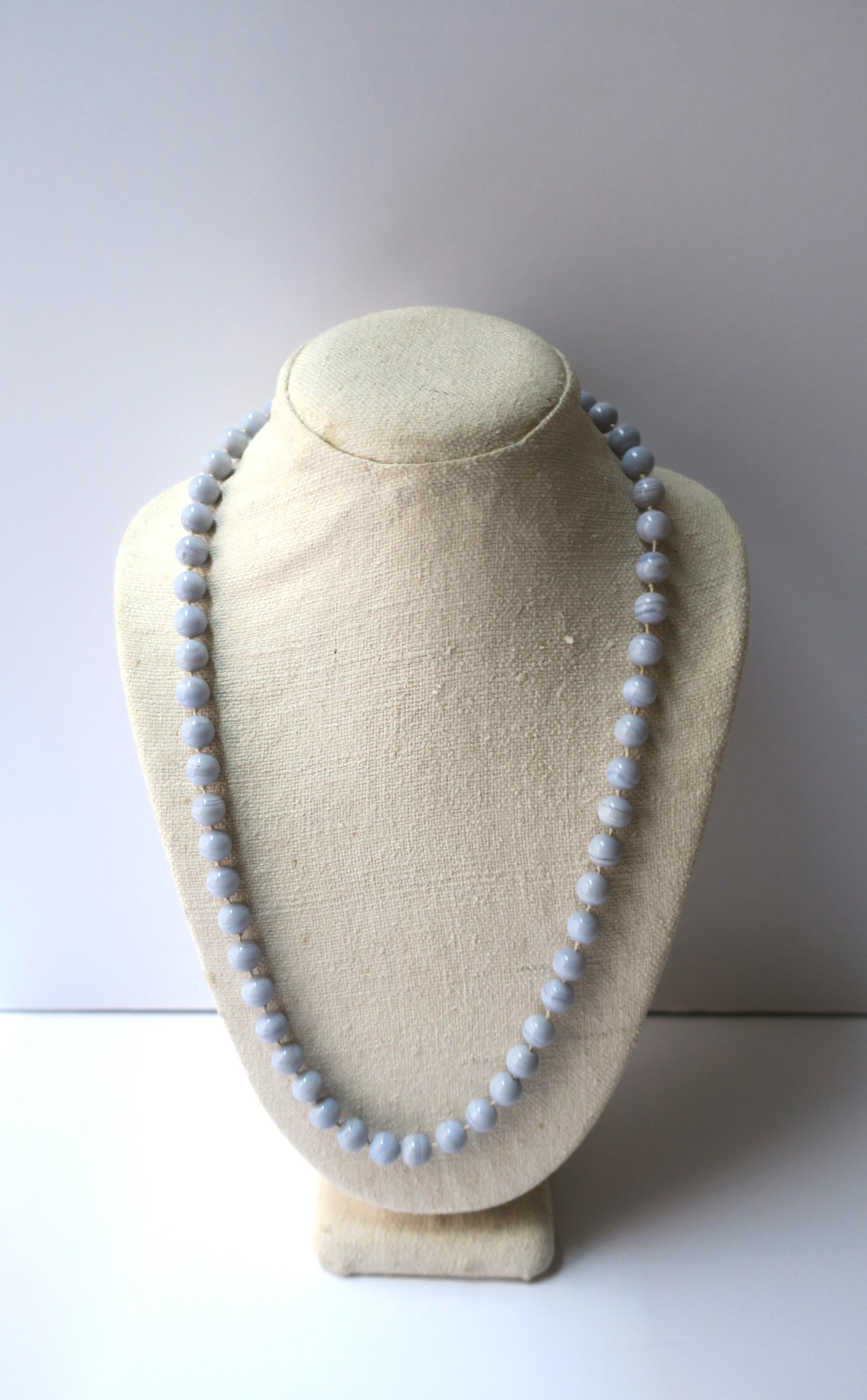 Una bellissima collana di perle di quarzo calcedonio, risalente alla metà o alla fine del XX secolo. Le perle sono di colore blu pervinca chiaro, lucidate e lisce, con un filo di seta annodato tra una perla e l'altra. Dimensioni: 26