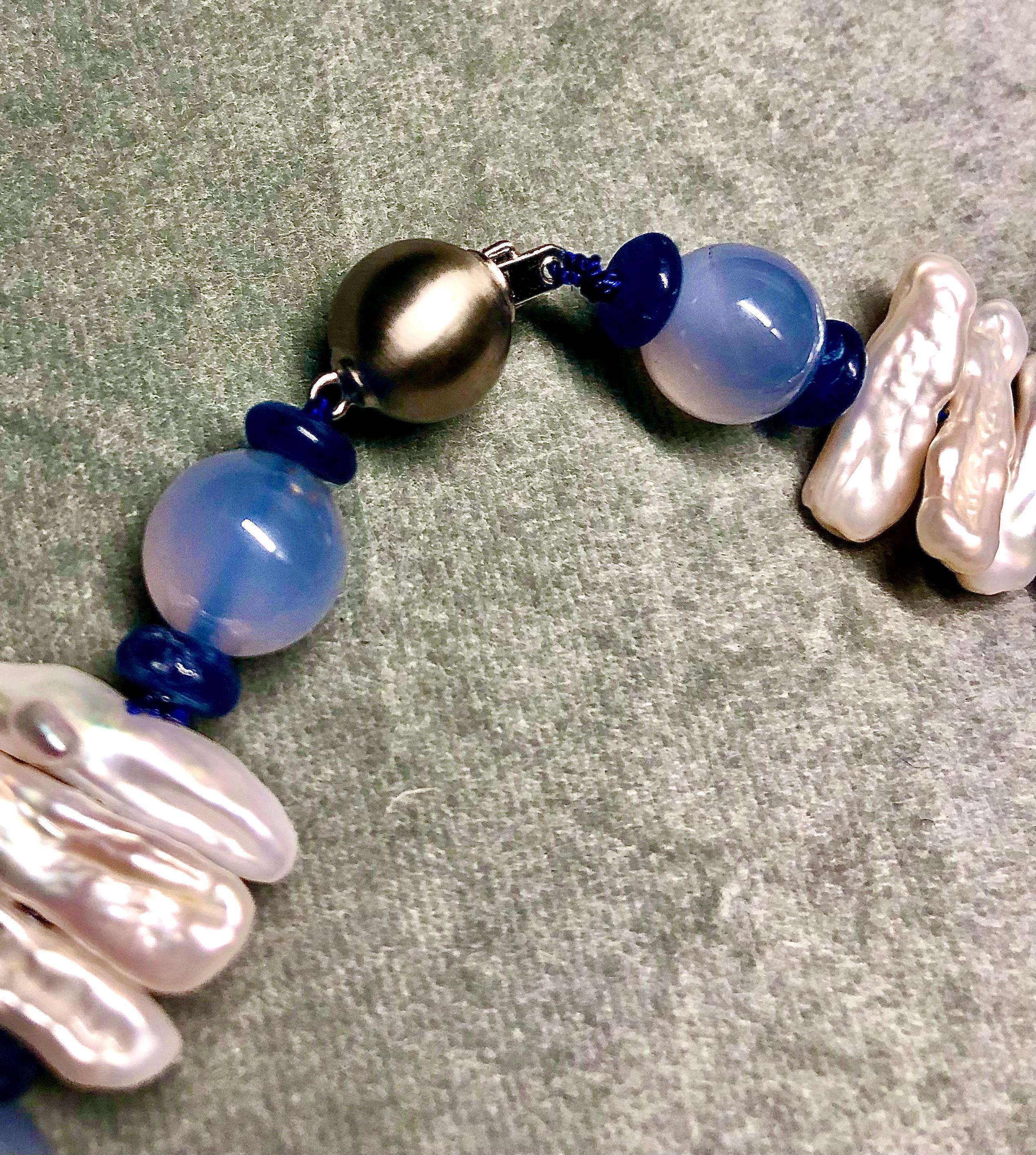 Unusual and striking abstract juxtaposition of luminous blue chalcedony spheres flanked by blue sapphire rondelles. Interspersed with lustrous Keishi solid nacre stick pearls. A pretty necklace that works for both day and night. Finished with a