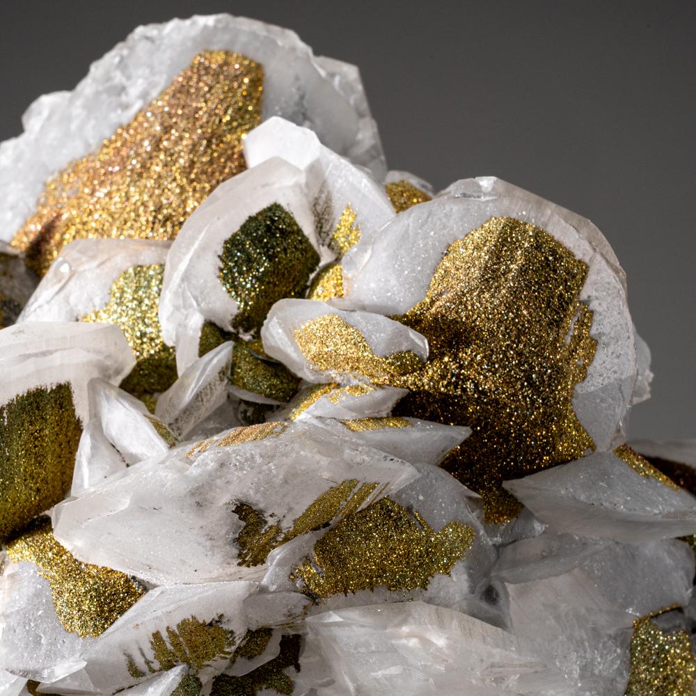 From Edong Mining District, Daye, Hubei, China

Cluster of sharp scalenohedral calcite crystals partially covered with lustrous iridescent metallic chalcopyrite crystals on the surfaces. Bright and lively color of blues ,greens and reds.

Weight: