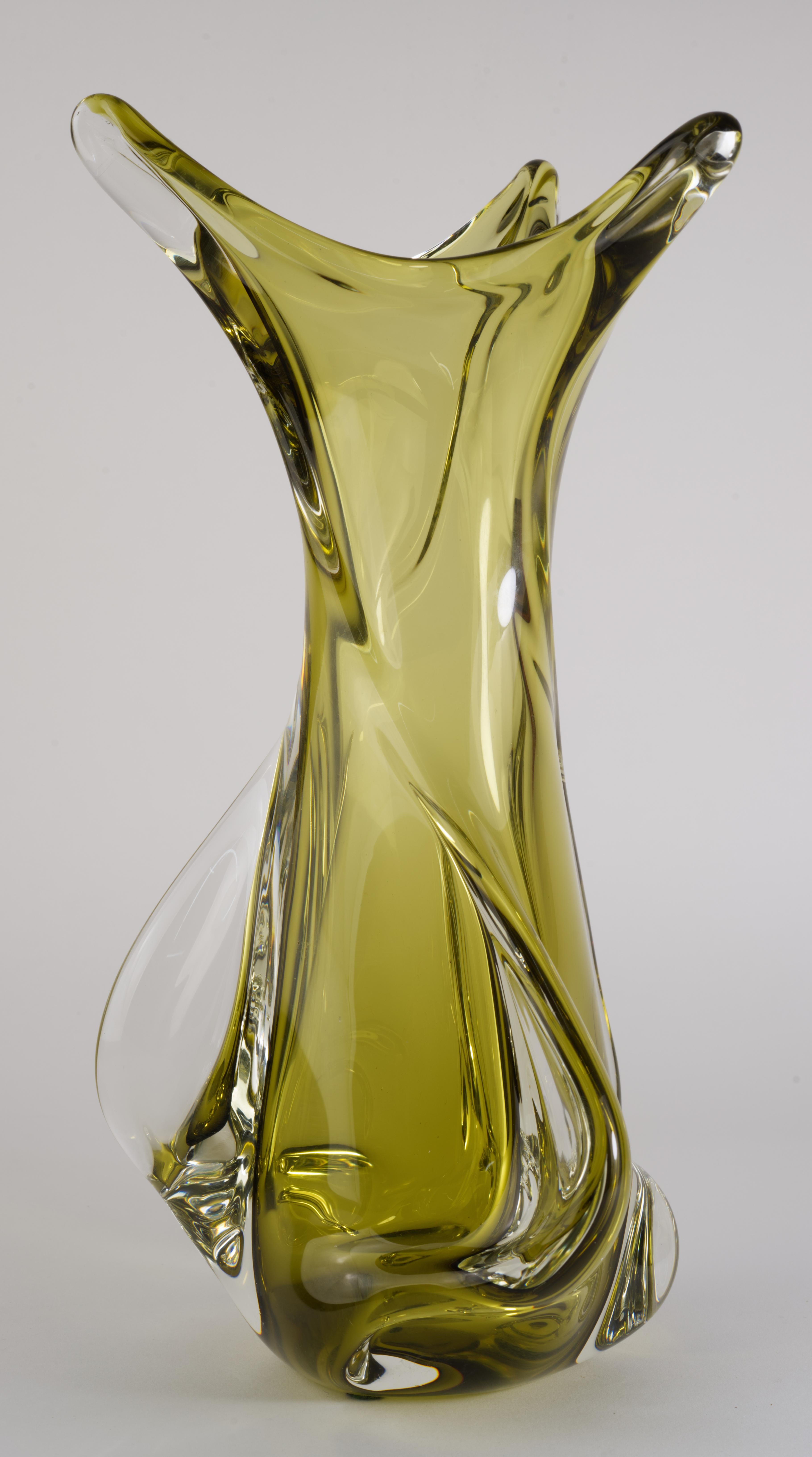 Il vaso in vetro artistico della metà del secolo scorso è stato realizzato da Chalet con la tecnica del sommerso, con vetro verde raccolto e ricoperto da vetro trasparente. La sua caratteristica forma sinuosa e libera è accentuata da pinne