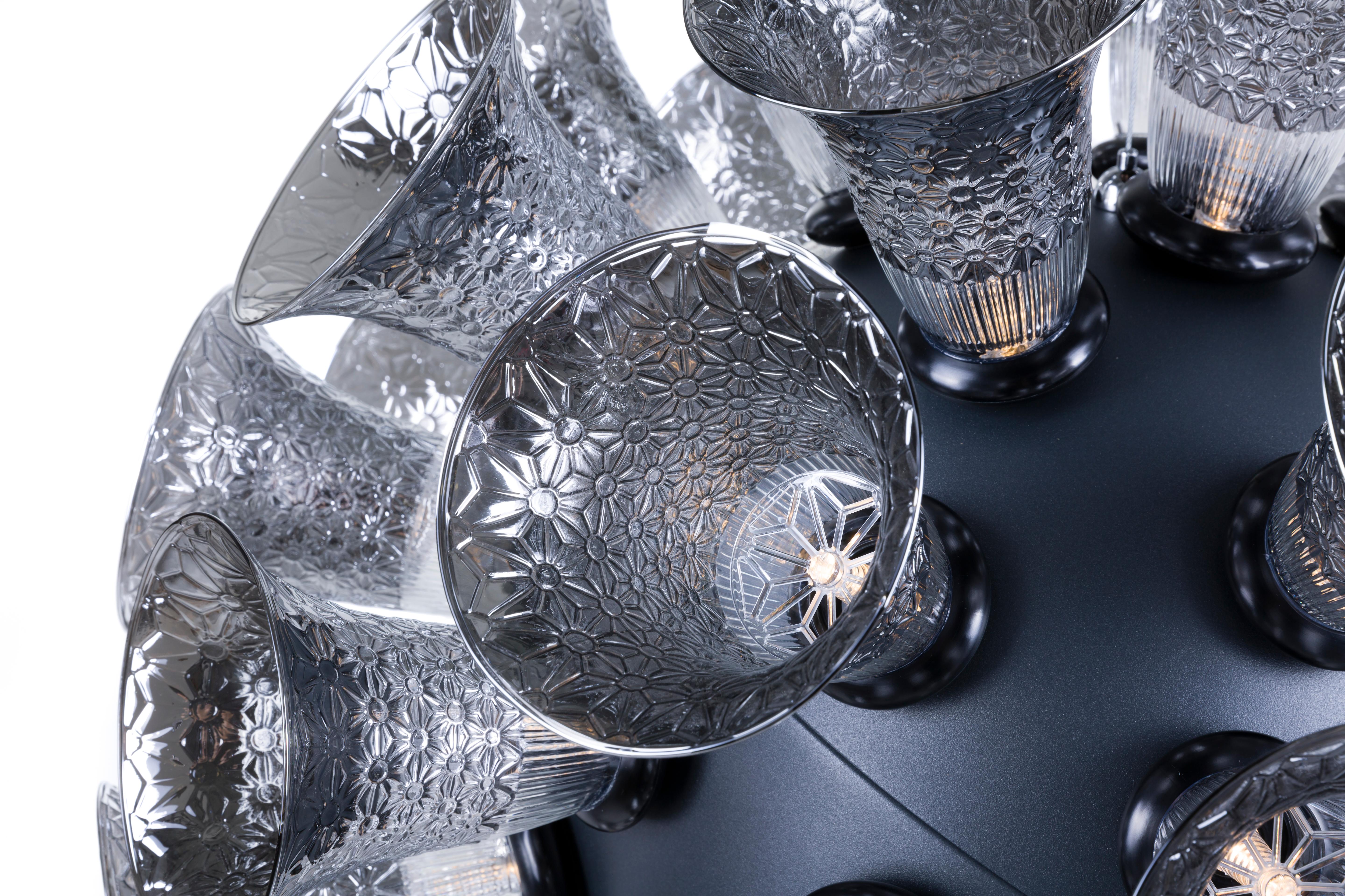 The fine crystal beauty of the Chalice lamp is enhanced by a soft metallic-grey body with black rings at the base of each translucent silver glass chalice. The result is a new bouquet of light.

The Chalice is produced with a black powder coated