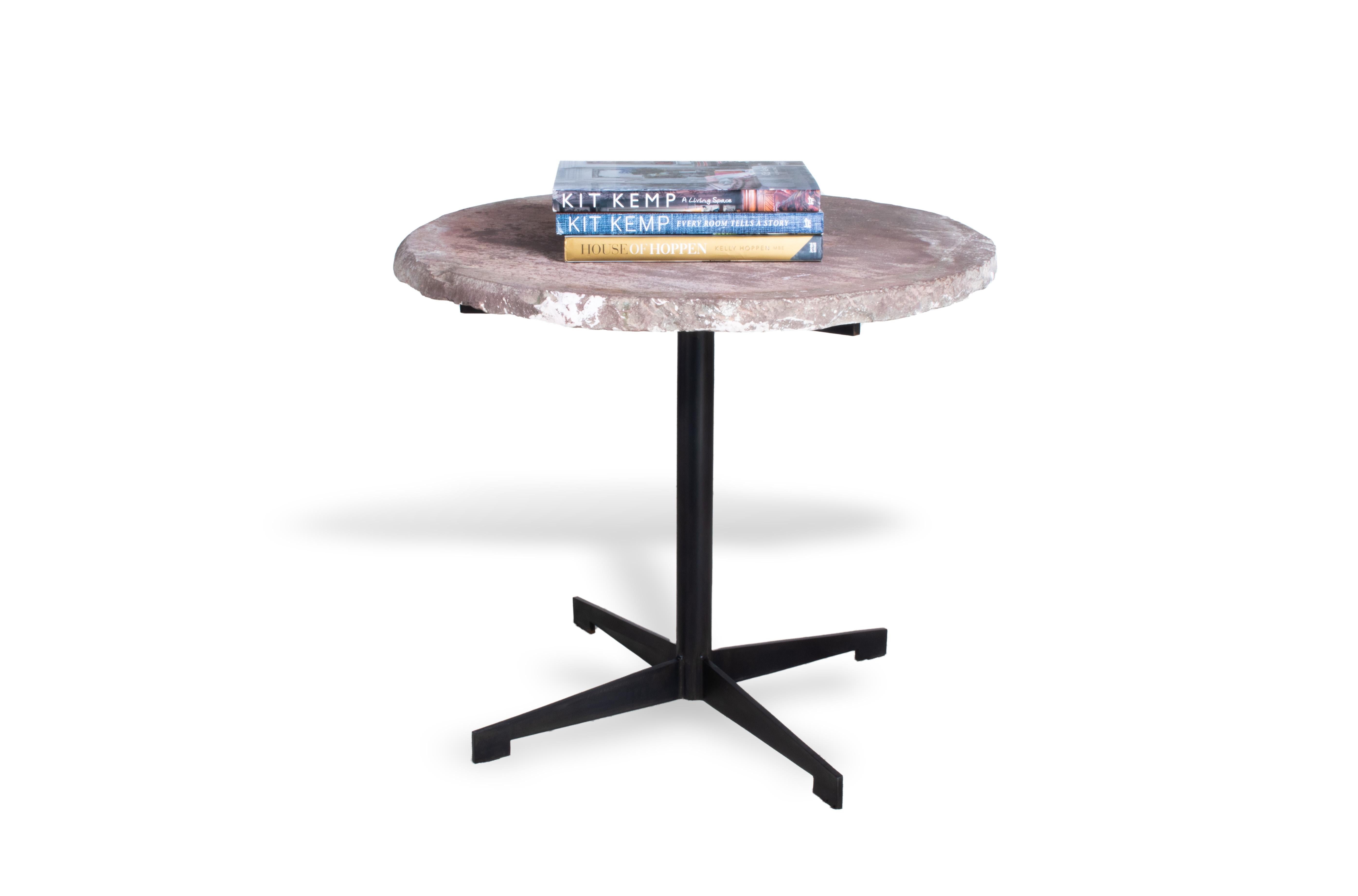 A stunning, modern and creative piece of furniture, this circular tabletop is crafted from chalkstone, a natural material with unique and organic detailing. Set atop an ebonized steel base, this table is perfect for your home. For a chic coffee