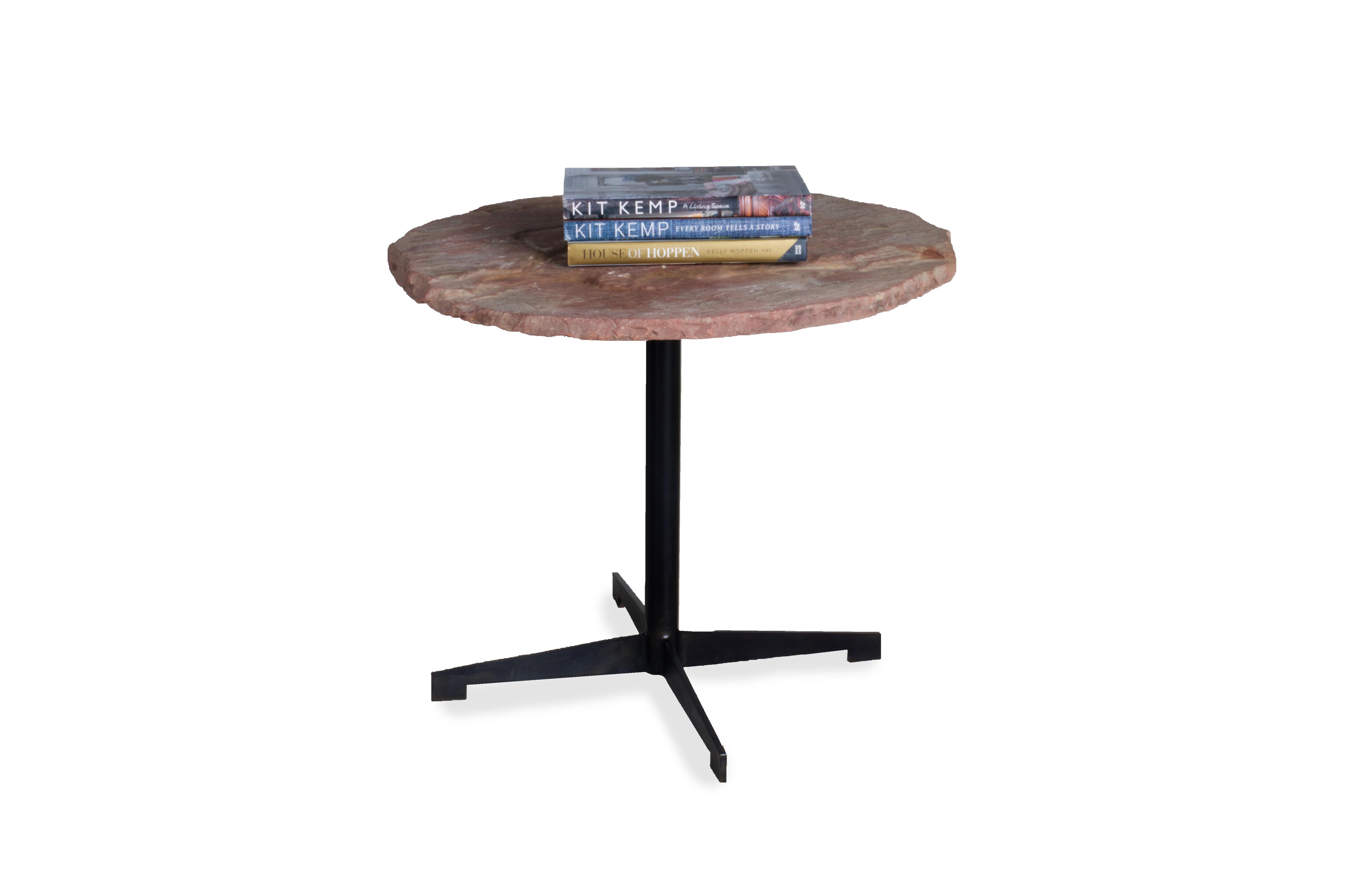 A stunning, modern and creative piece of furniture, this circular tabletop is crafted from chalkstone, a natural material with unique and organic detailing. Set atop an ebonized steel base, this table is perfect for your home. For a chic coffee