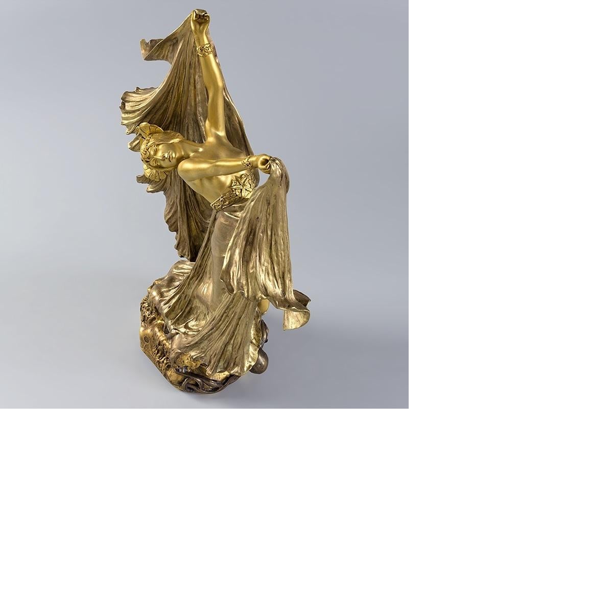 This gilt bronze figural sculpture by Louis Chalon depicts a dancing woman with an octopus at her feet, one of its tendrils wrapped intimately around her leg. Her rolling unfurled veils, imbuing her with exoticism, as her free-form dance movement