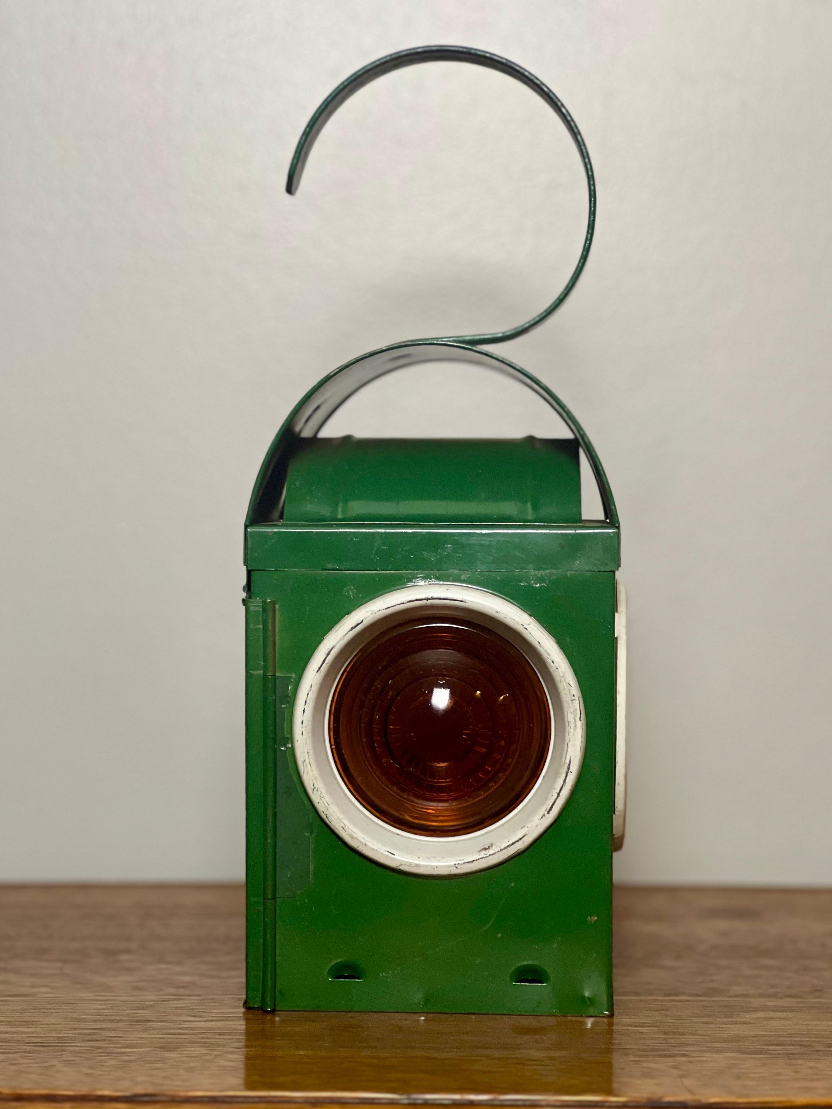 Collectible vintage Chalwyn green railroad kerosene signal lantern, made in England. Lantern is complete with original burner, white portholes, functional hinged door and intact amber lenses. Great decorative item for a bookcase, mantle or porch and