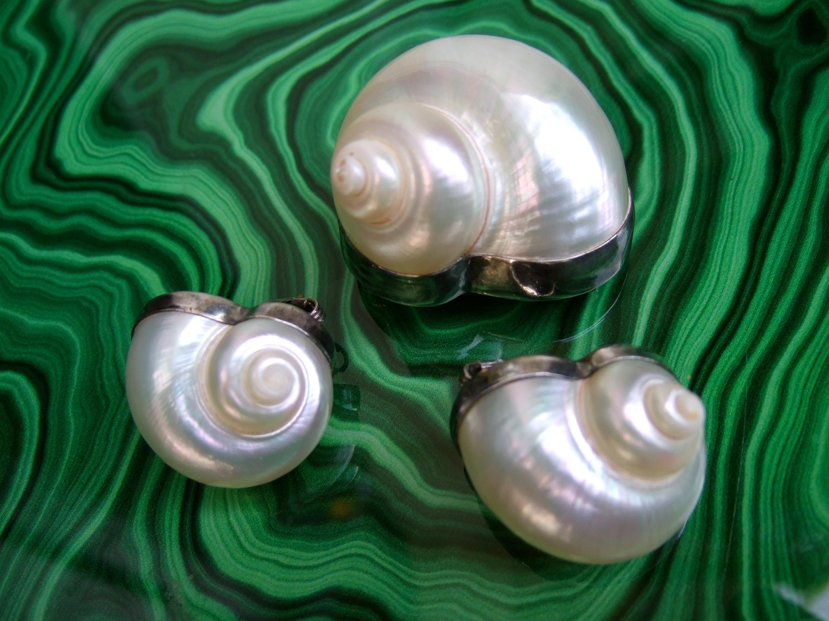 Chamber Nautilis sea shells in sterling bezels designed by Betsey Fuller c 1986
The handmade artisan sea shell brooch & clip on earrings are made
with luminous pearlized organic sea shells set in sterling silver bezels 

Makes a very elegant unique
