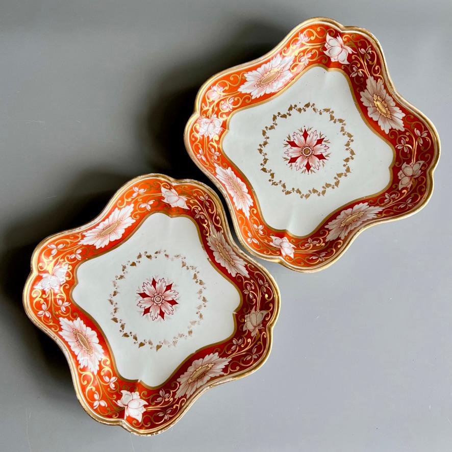 This is a beautiful pair of square dishes made by Chamberlains Worcester in about 1810. The dishes have a nice lobed shape, and a stunning orange ground border with a richly gilded floral pattern, and an elegant gilt wreath and flower in the