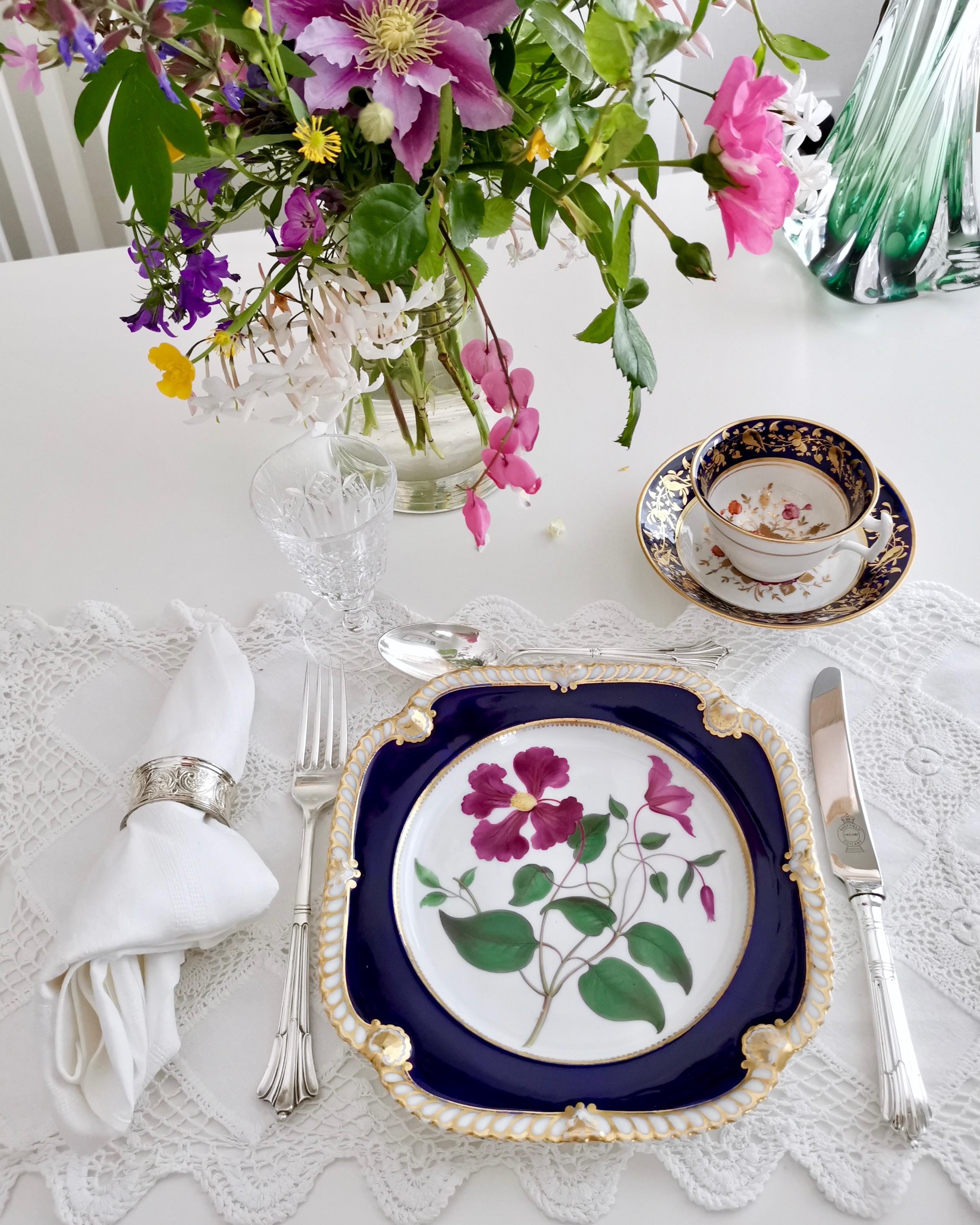 This is a stunning dessert plate made by Chamberlains Worcester in about 1820. The plate has a deep cobalt blue ground and a gorgeously hand painted clematis flower in the centre. 

The Chamberlain factory was founded in the 1780s by Robert