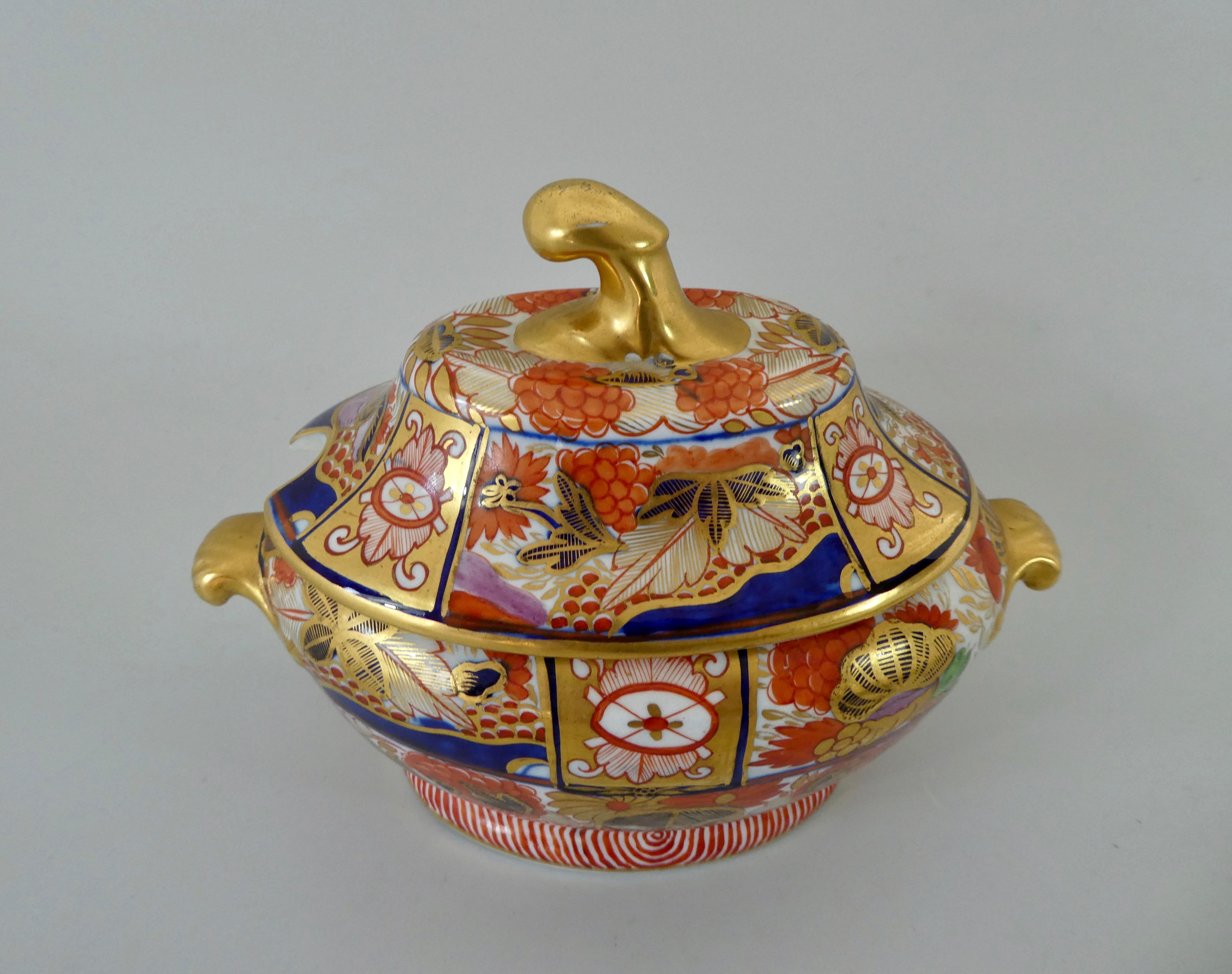 Chamberlains Worcester porcelain sauce tureen and cover, circa 1800. Finely hand painted in a rich Imari pattern, with panels of stylized plants. The tureen having gilt scroll handles, and the cover surmounted by a gilt scroll finial.
Measures: