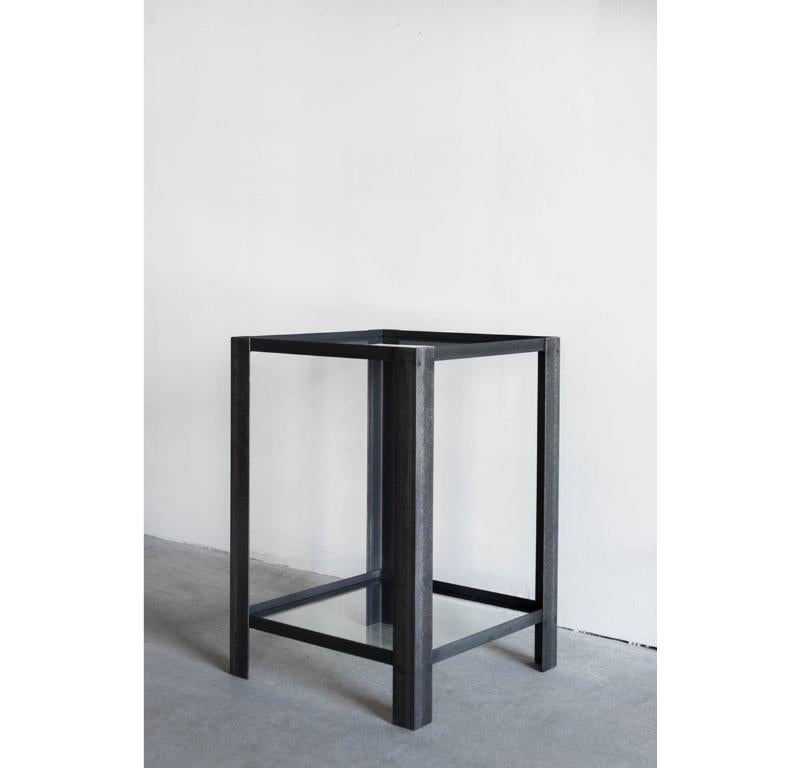 La table d'appoint Chambers est une pièce d'accent industriel discrète. Son cadre en acier aux lignes épurées et aux tons froids est associé à du verre encastré sur les étagères supérieure et inférieure, créant ainsi une paire de surfaces