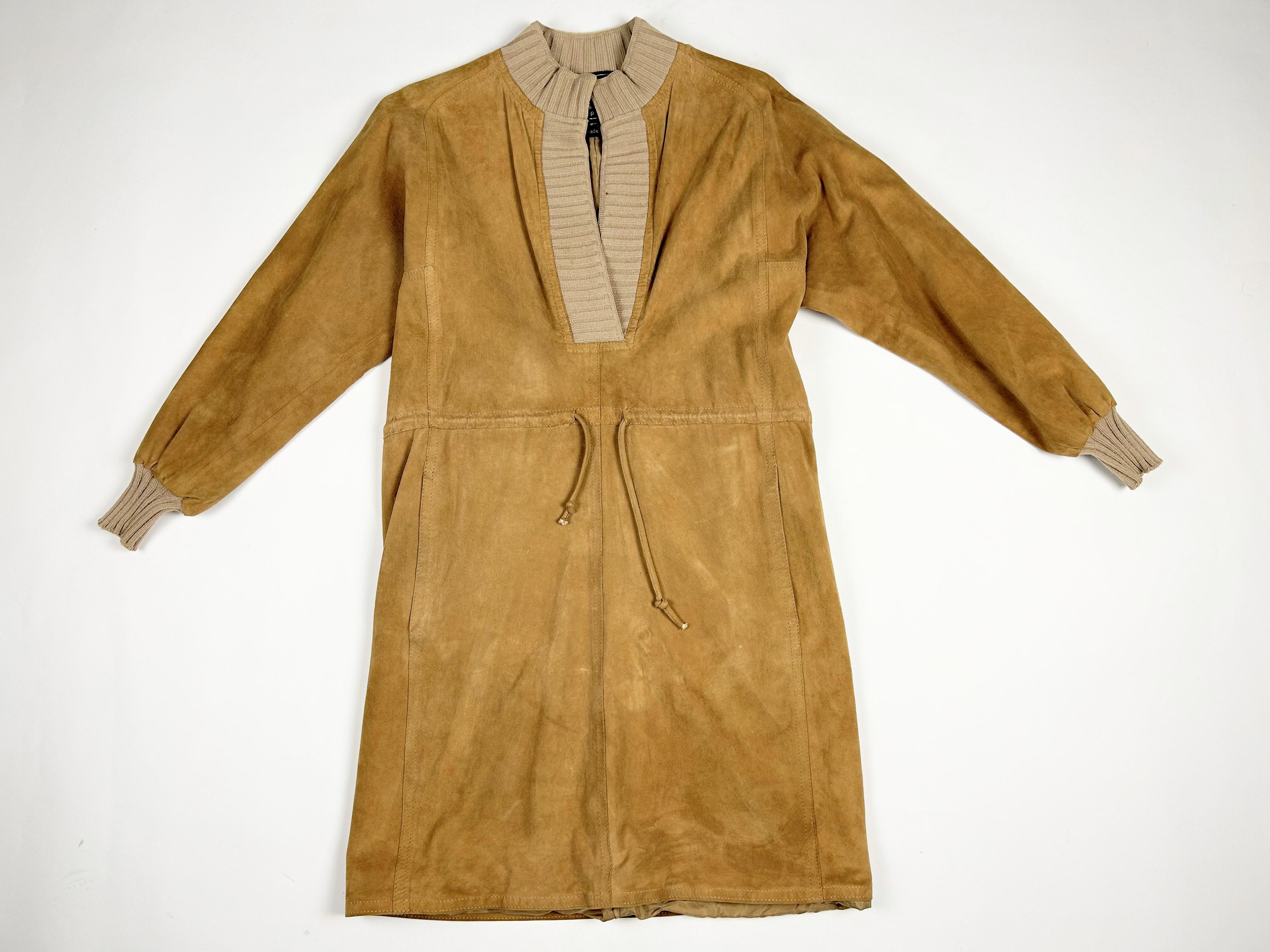 Circa 1982

France

Amazing short safari-style dress in buff-coloured suede by Emanuel Ungaro Parallèle dating from the early 1980s. Straight cut with puffed sleeves and stitched inserts. Beige stretch knit with turtleneck effect collar and cuffs.