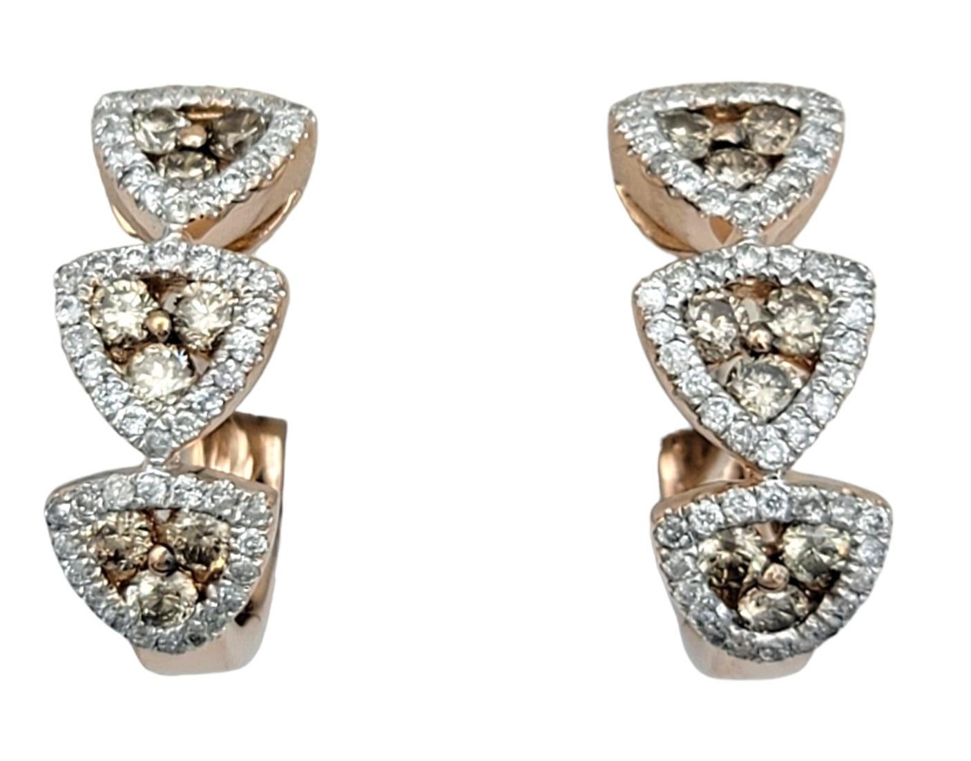 These captivating hoop earrings crafted in 14 karat rose gold are a stunning work of art. Each earring features a trio of striking triangles adorned with champagne / light brown diamonds surrounded by bright white diamonds, creating a mesmerizing