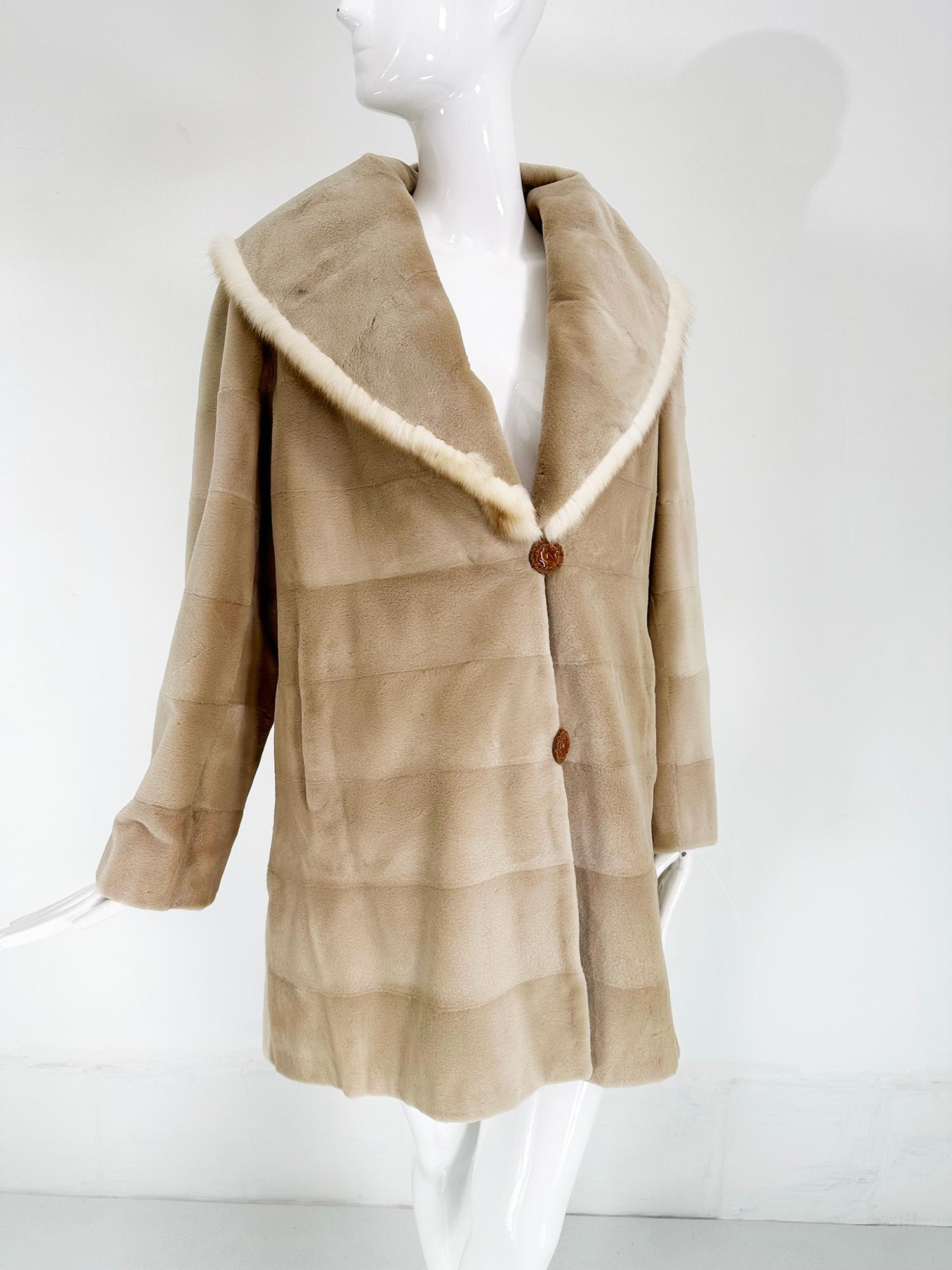 Champagne blond sheared mink reversible jacket with a full shawl collar. This beautiful jacket is very soft and is reversible to a taupe polished cotton blend fabric. The lining has hand stitched decorative detail. The coat closes with handmade