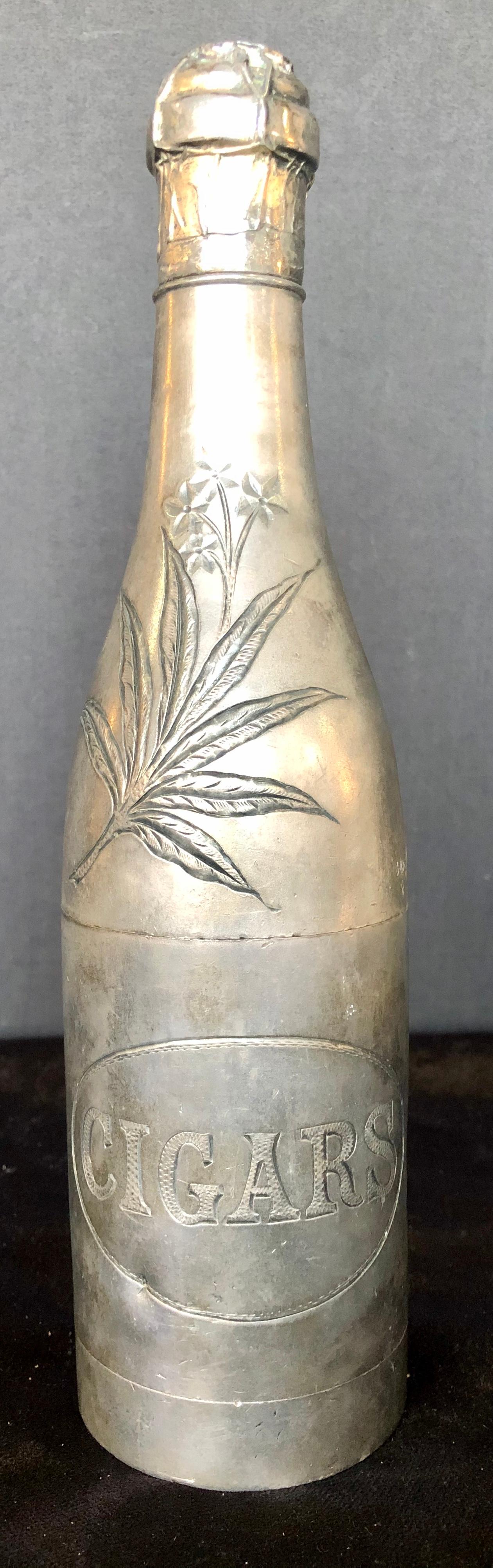 A silver plated, American 1920s, cigar holder in the shape of a Champagne bottle.
Well patinated silver plate. Very Gatsby-esque!
Wonderful detail to the top, with an engraved tobacco leaf.
The base is marked Pairpoint MFG CO, New Bedfortshire,