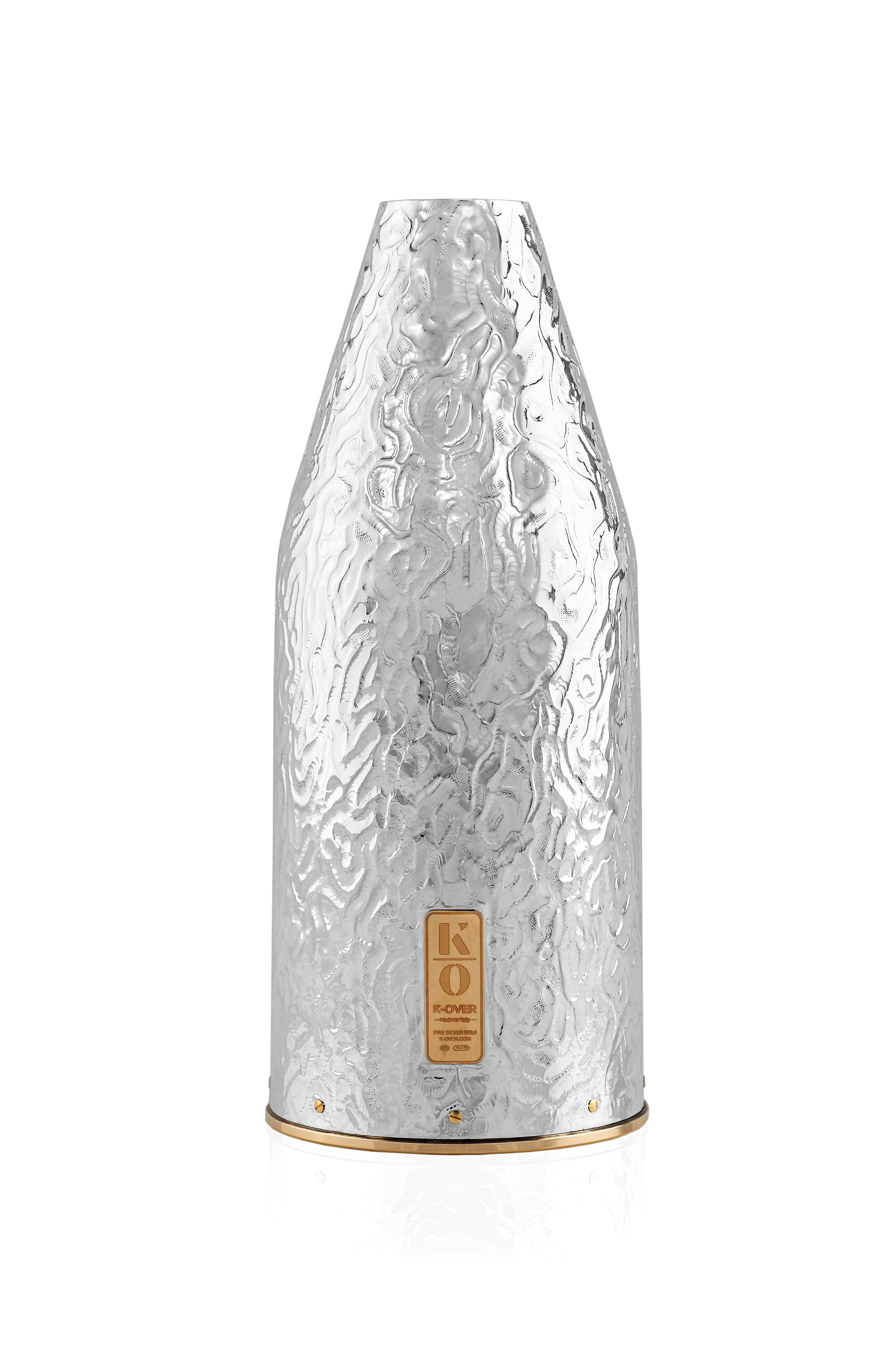 Voici une pièce distinguée de notre Collection K-OVER Nature, Timone, un cache-bouteille de champagne en argent pur 999/°°, magistralement inspiré du monde de la plaisance. Ce design innovant capture l'essence de l'élégance maritime, ce qui en fait