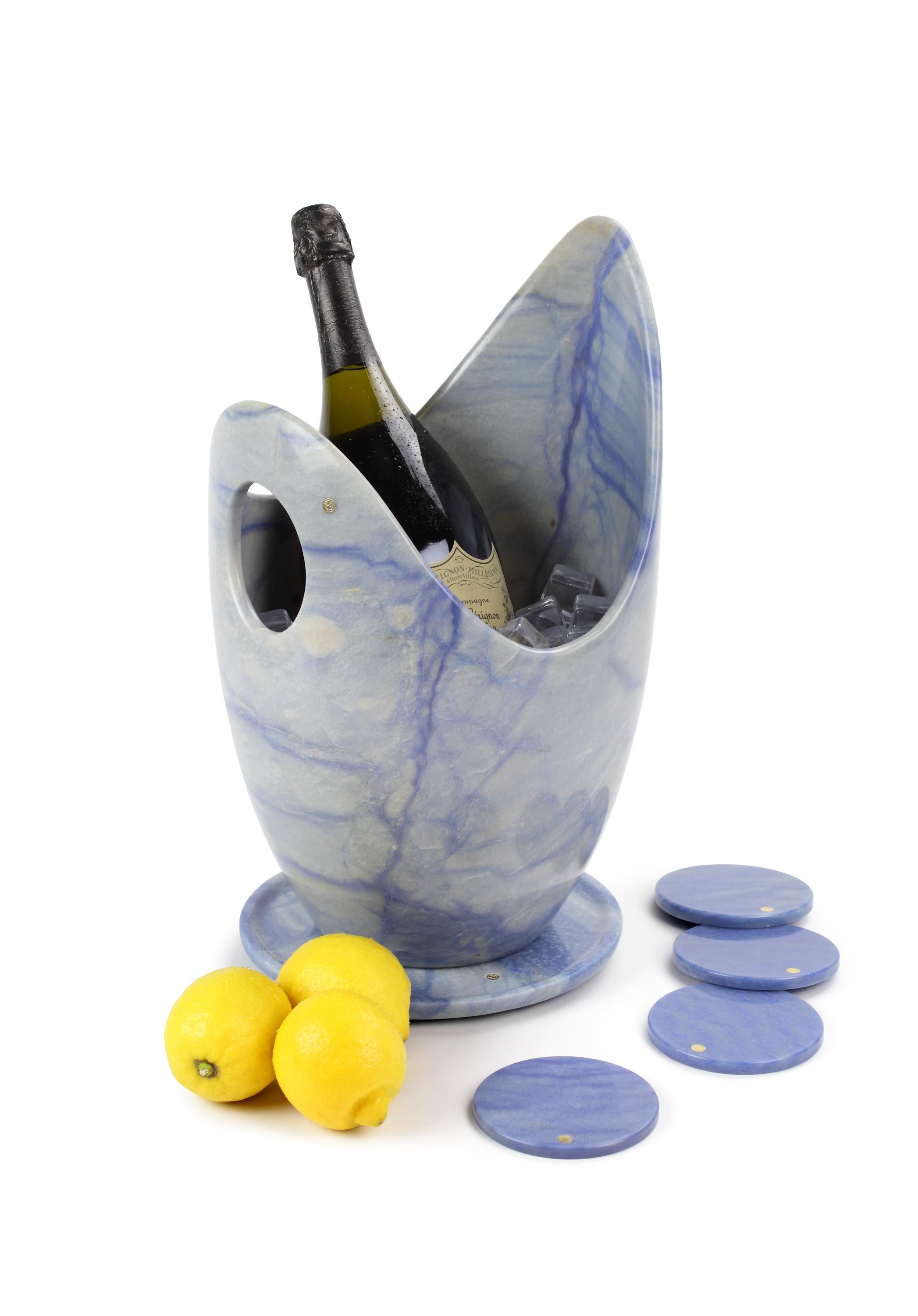 Luxurious and big Champagne bucket set sculpted by hand from a solid block of Azul Macaubas. 
The set consisting of 1 Champagne bucket, 1 circular plate and 4 circular coasters. Polished finishing. 

Champagne bucket dimensions: D26 H 41 cm.