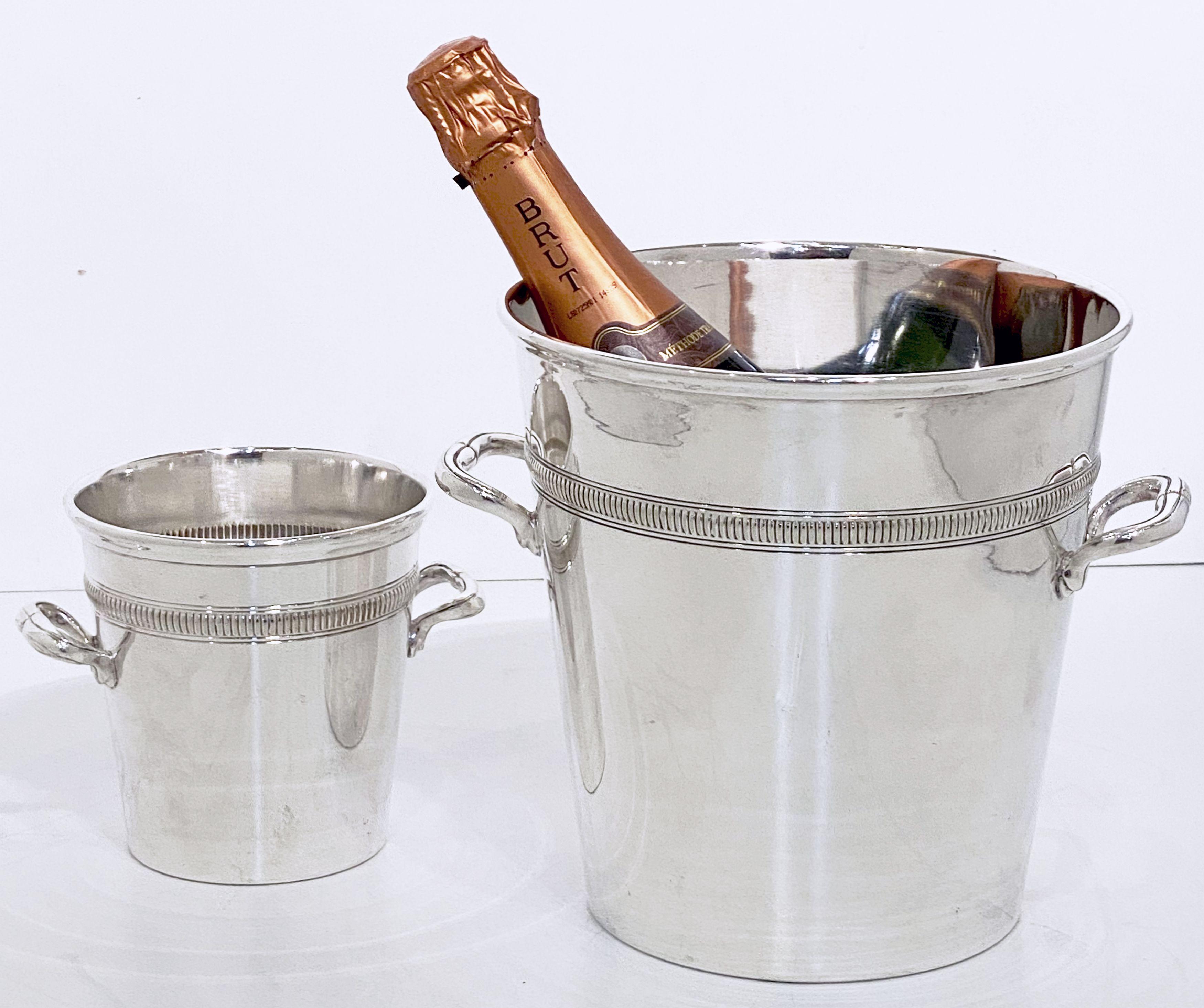 A handsome matching bar set from early 20th century France, featuring a large champagne bucket and a small ice bucket of fine plate silver - each with rolled top edge, two opposing handles, and tapering body with an elegant Edwardian style