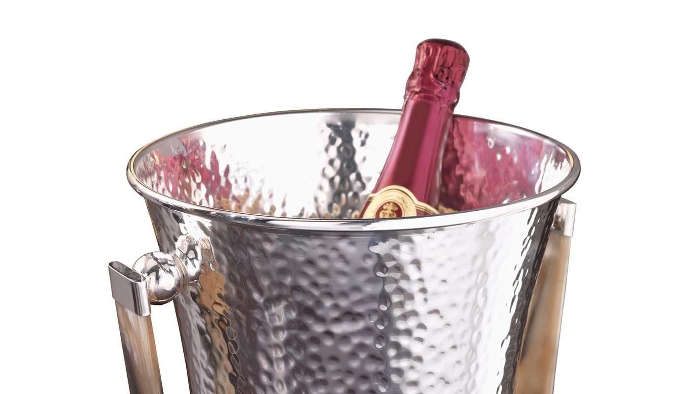 A timeless accessory for a cocktail cart or a bar cabinet in both classic and modern decors, this sophisticated champagne bucket will add glamour to formal dinners and entertaining events. Crafted of silver plated brass entirely hand-chiseled with