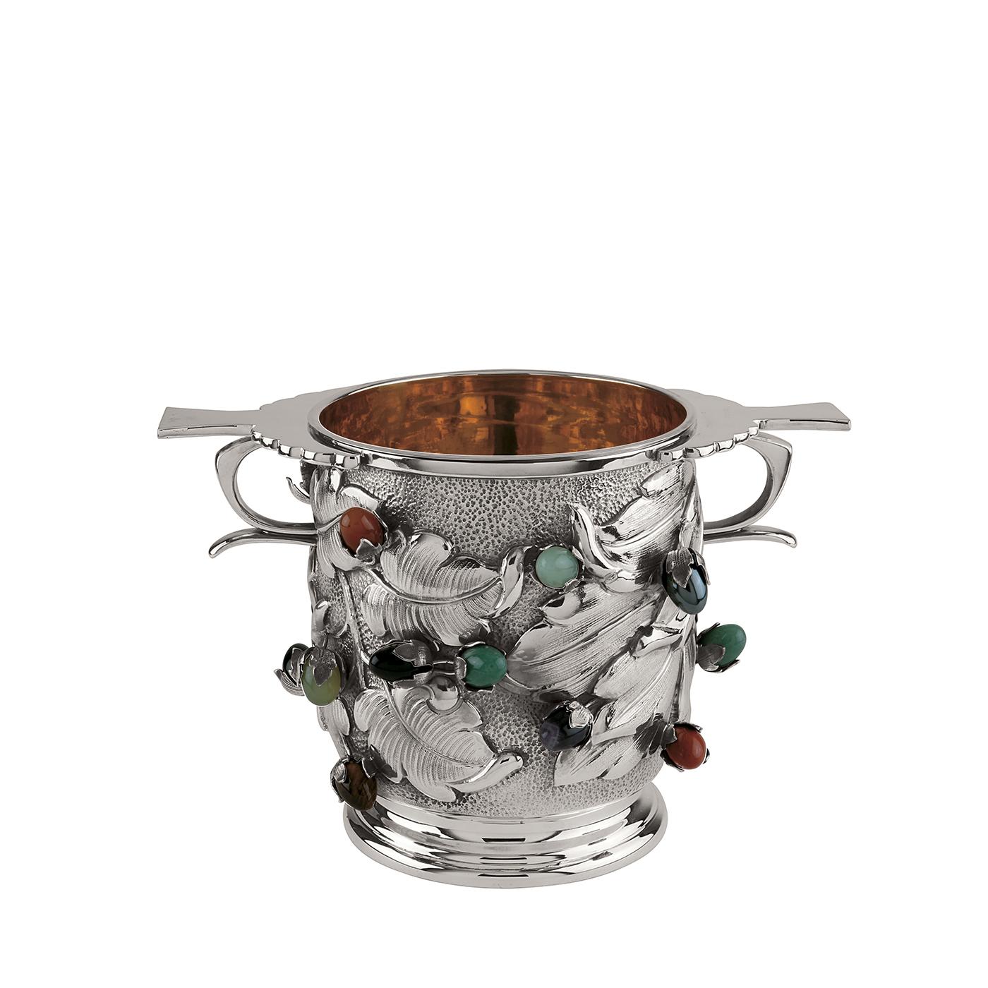This majestic silver champagne bucket combines artisanal craftsmanship and artistic flair and will add a sophisticated touch to a celebratory event. The bucket carries a removable bowl internally finished in gold, while the exterior features two