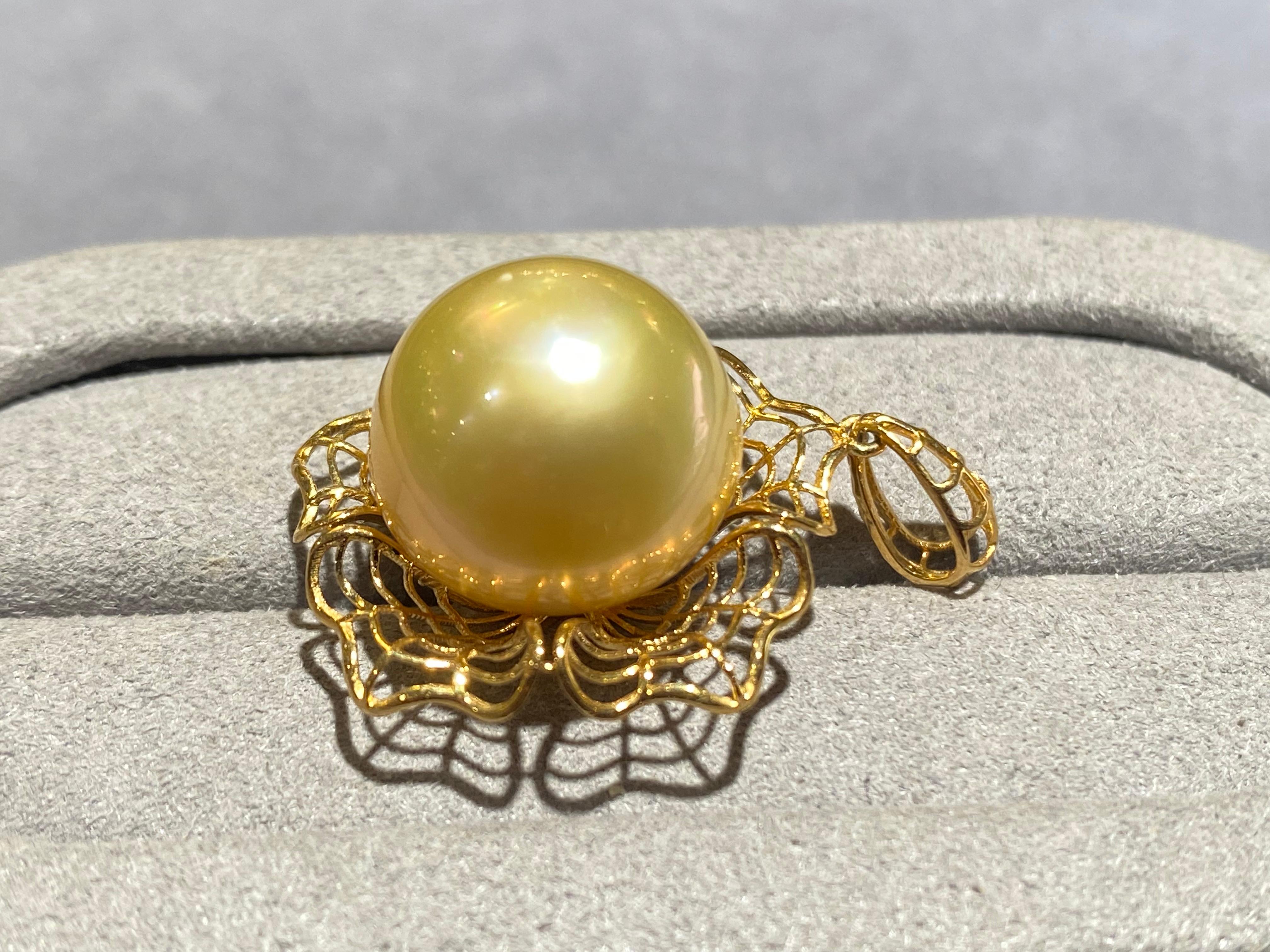 A 14.7 mm button champagne colour south sea pearl pendant in 18k yellow gold. This pendant is a flower design with the pearl set in the middle of the pendant. The pendant is in a mesh form and the bale matches this form as well. It is a very simple