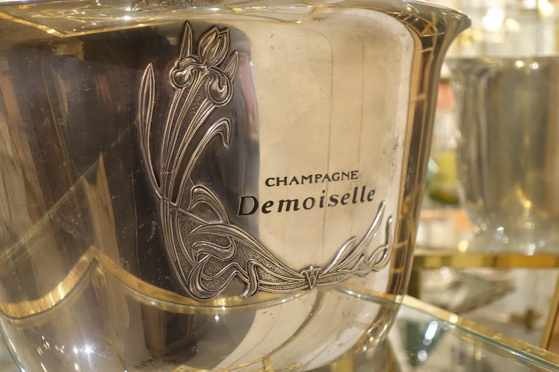 Fabulous and seldom seen champagne / wine cooler, originally used at hotels / restaurants. Holds 5-6 bottles, and is characterized by the Champagne Demoiselle markings, and its lovely Art Nouveau floral motif of an iris. Demoiselle champagne is