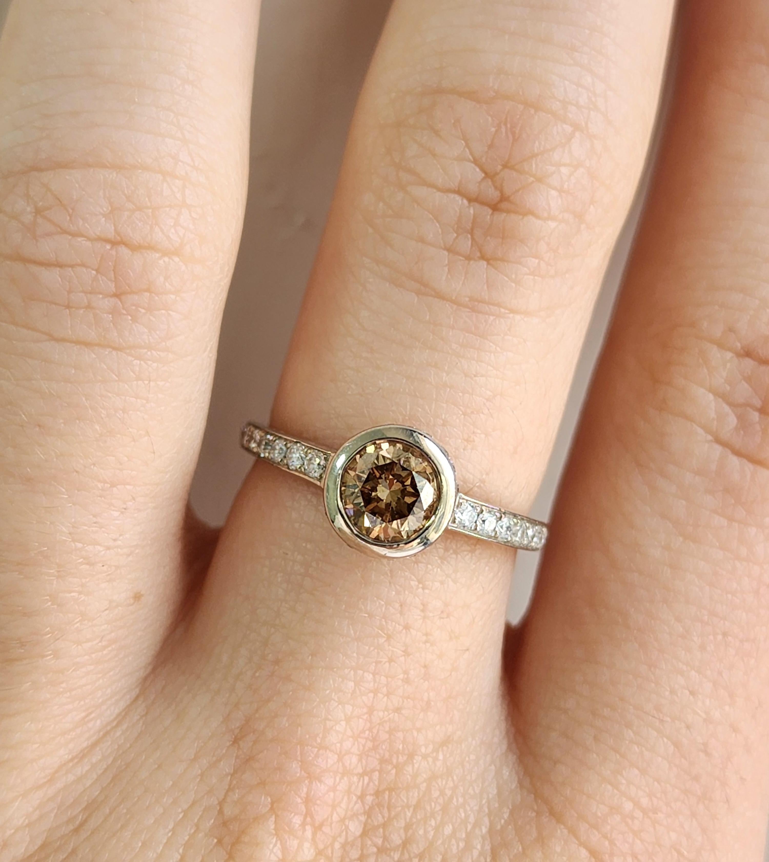Champagne Color Diamond with Diamond Halo Ring in 18K White Gold
Elegant Diamond Ring, who's centerstone is a light brown/champagne colored diamond (Total Weight 0.84 Carat) set into an 18 K White Gold Halo Setting adourned with round small diamonds