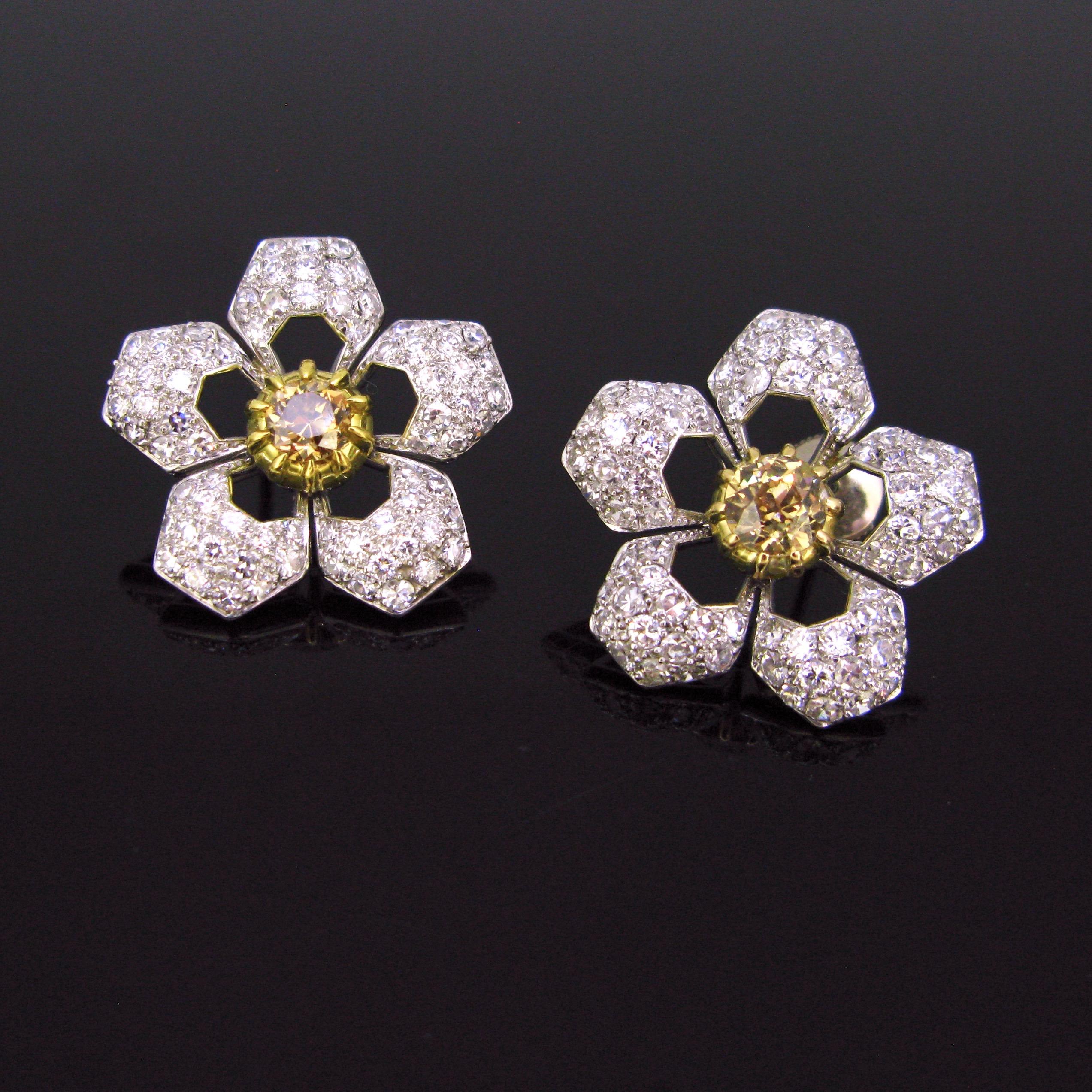 This pair of earrings is adorned with a champagne diamond in its centre. They have a deep yellowish brown colour and they weigh around 1ct each. The petals of the flower are adorned with white and sparkly brilliant cut diamonds (75 diamonds per