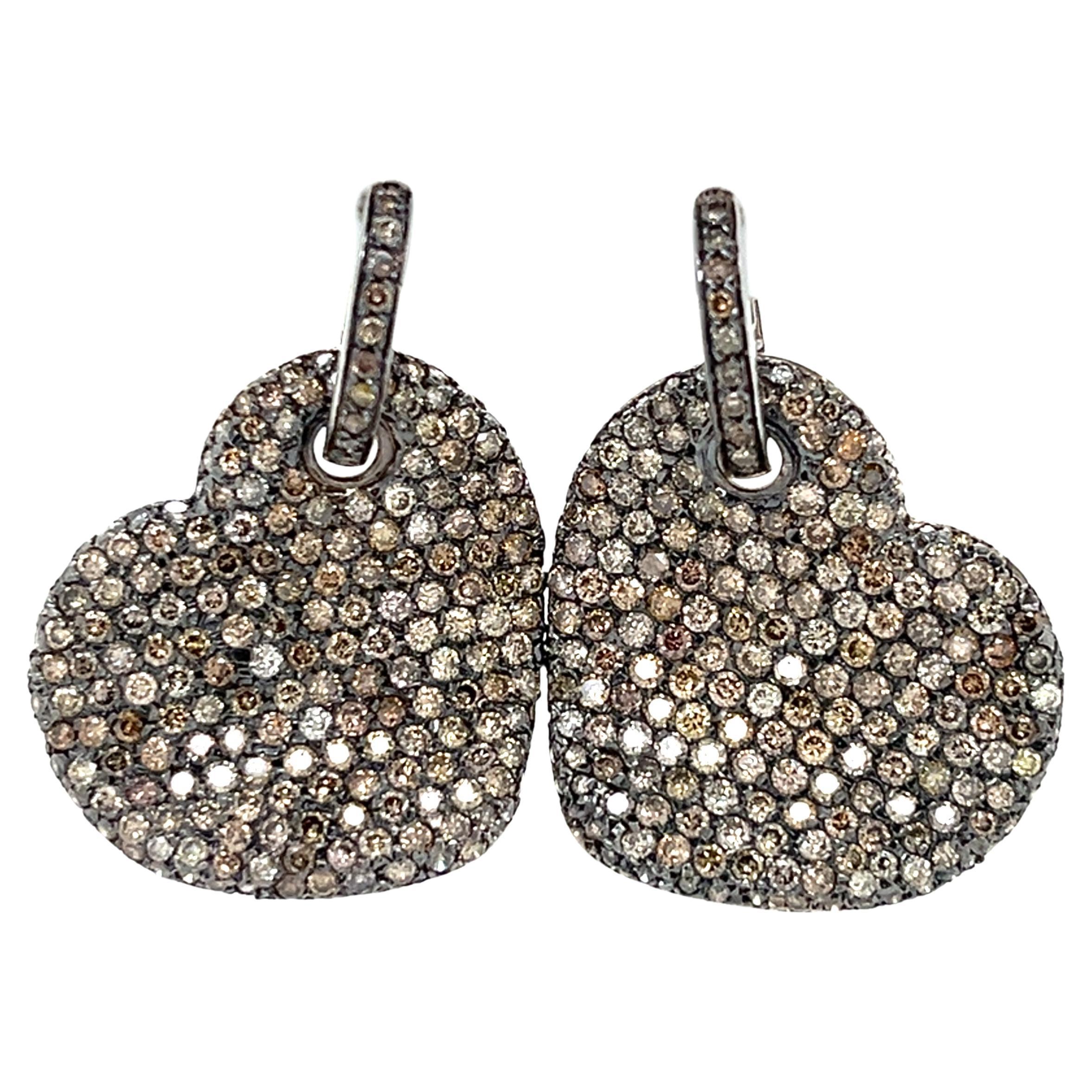 These Champagne Diamonds Heart Earrings in 18kt white gold blend romantic elegance with a touch of luxury. The heart-shaped design is adorned with shimmering champagne diamonds 5.40 carats aprox, set against the crisp backdrop of white gold,