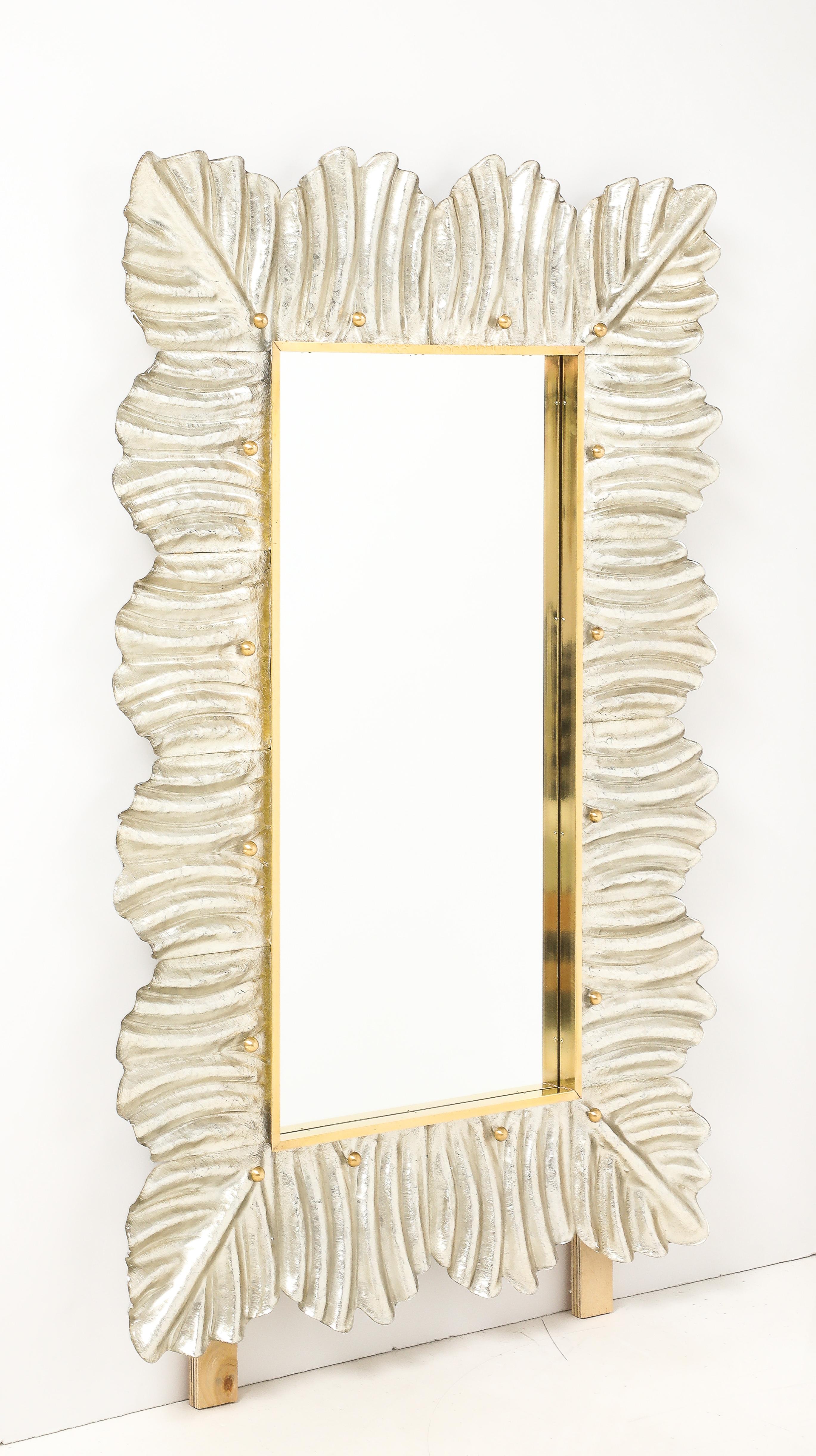 Exquisite Murano Glass Mirror in a luxurious Champagne color (gold/silver hue). These mirrors are hand-crafted in Venice, Italy and feature elegantly designed sculptural Murano glass leaves that encircle a brass inlaid rectangular mirror. Each