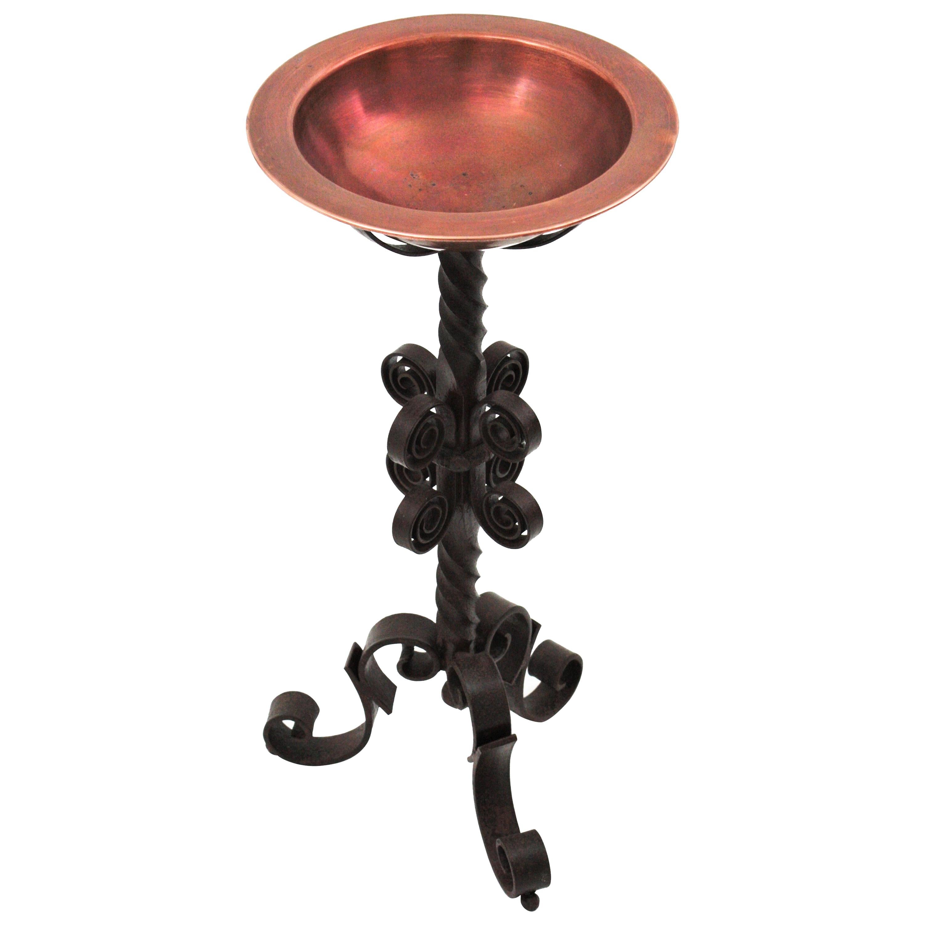 Scrollwork hand forged tripod stand with copper ice bucket, Spain, 1940s
This ice bucket serving stand is all made by hand. The handwrought iron stand has a tripod base with scroll ended feet and a richly scroll adorned twisted stem. Holding a