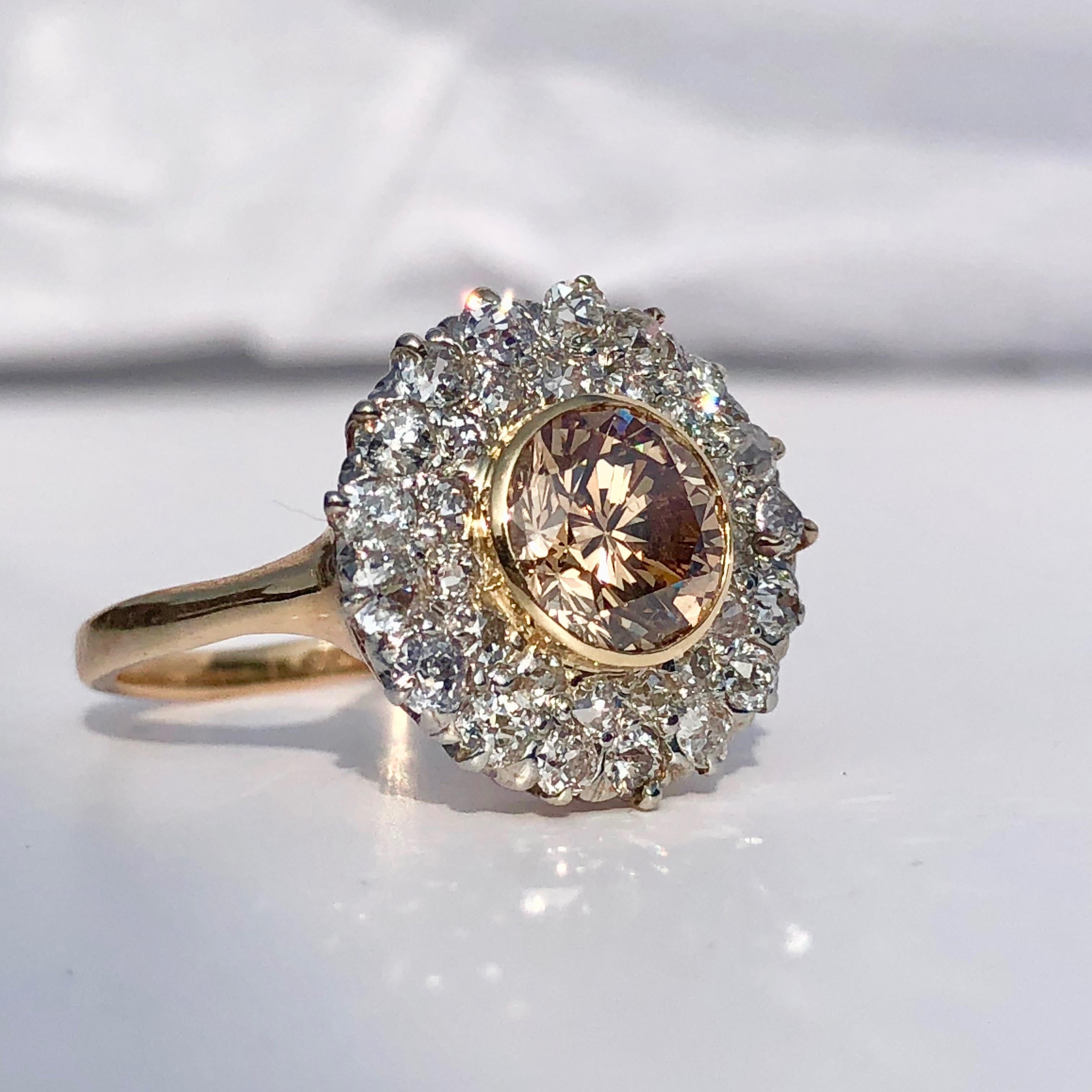 A rare peachy champagne diamond ring

The round brilliant cut principal diamond is a stunning hue, quite mesmerising.

The central diamond in a yellow gold collet setting with the old cut round white diamonds are each secured within claws - a