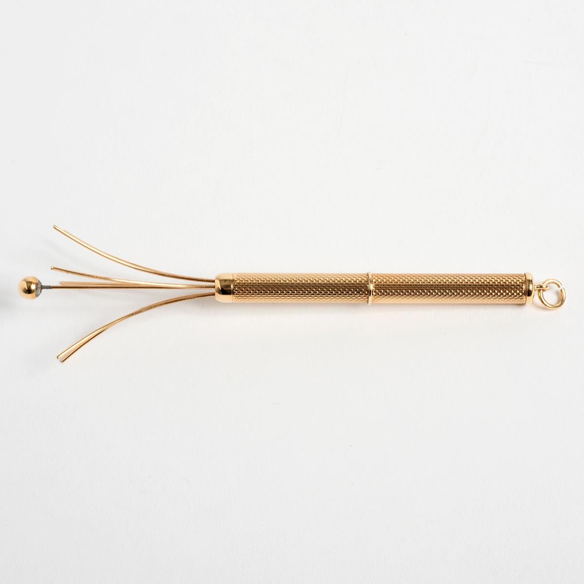 Popular in the roaring '20s and 1930s, a champagne swizzle stick was used to remove and reduce bubbles in a glass of champagne. This particular example also features a loop to the opposing end to fit to a chain or watch chain. The swizzle