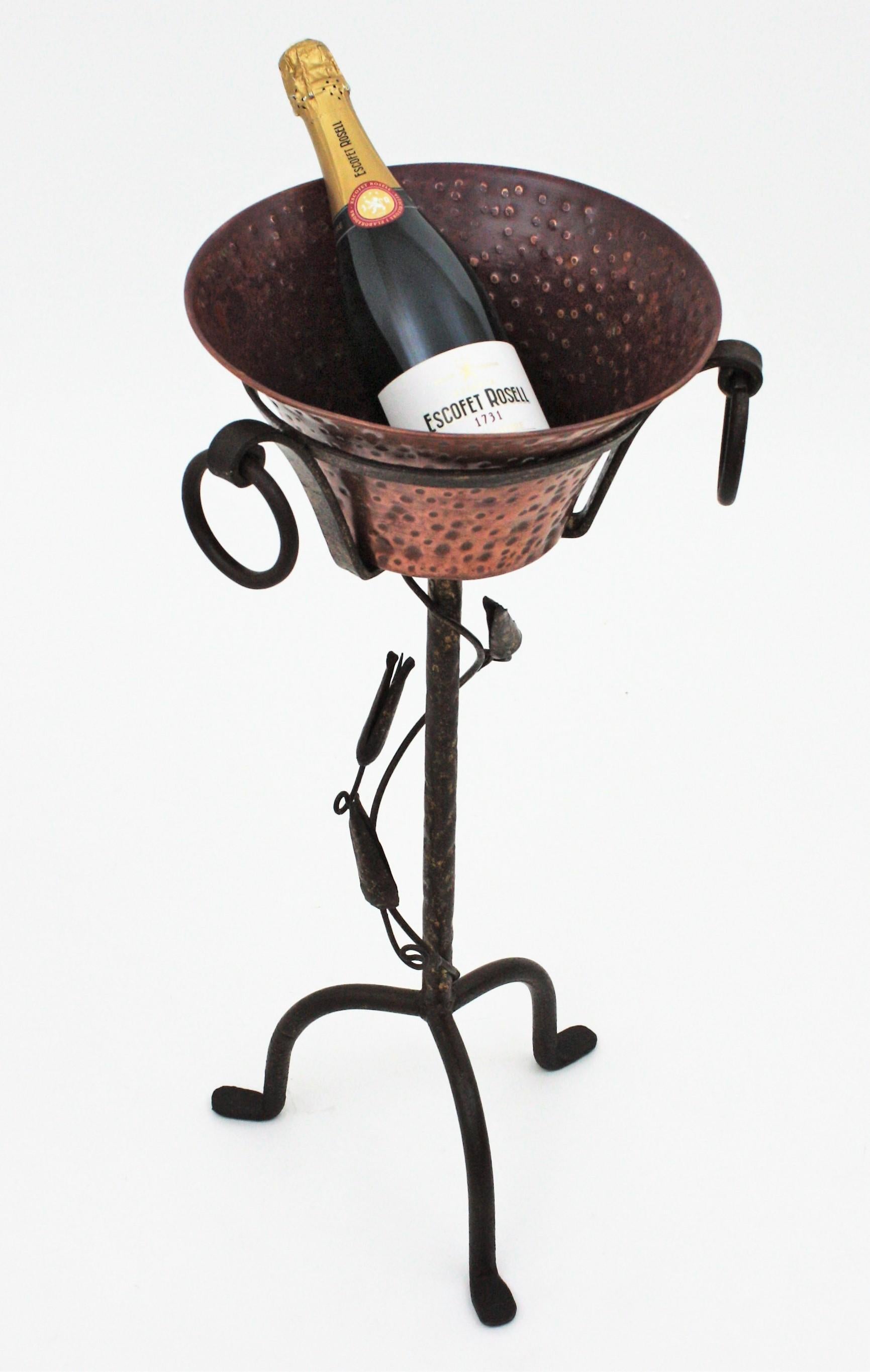 Parcel-gilt hand forged tripod stand with hand-hammered copper ice bucket, Spain, 1930s-1940
This pedestal champagne serving stand is all made by hand. The handwrought iron stand has a tripod base with floral decorative details surrounding the stem