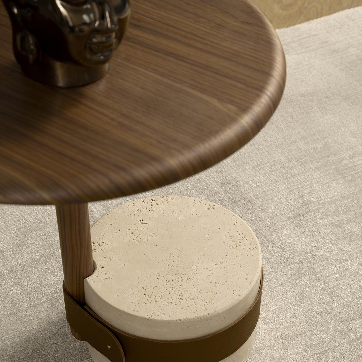 Cette table exquise dégage une élégance intemporelle grâce à sa base en marbre Travertino Romano méticuleusement travaillée, dotée d'une finition mate à pores ouverts et d'une boucle en cuir véritable de Cognac. La structure en noyer massif, teintée