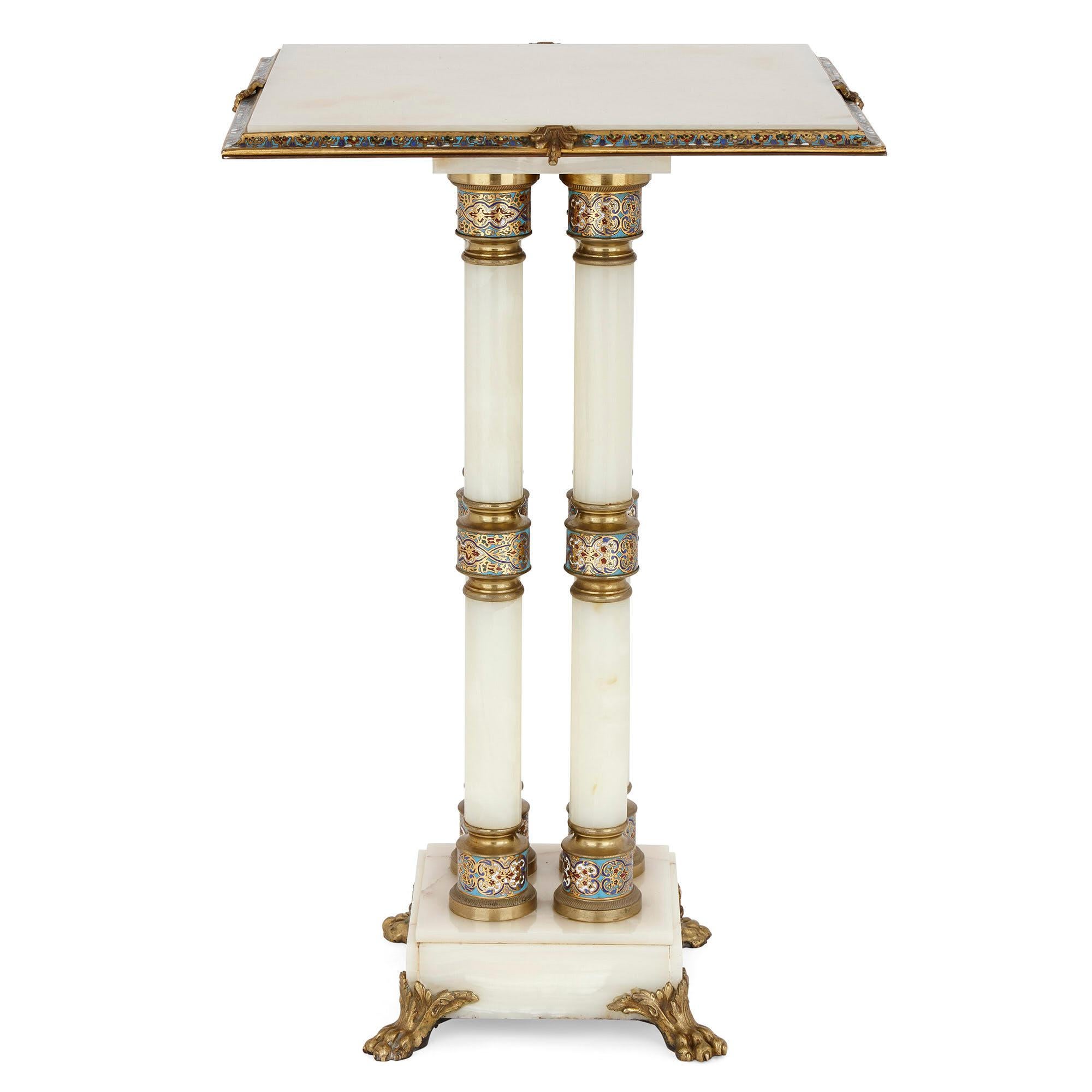 This stunning occasional table is crafted from onyx, gilt bronze, and champlevé enamel, the result being a beautiful combination of colours, textures, and materials. The square tabletop, of white onyx, is edged with a gilt bronze mount, the gilt