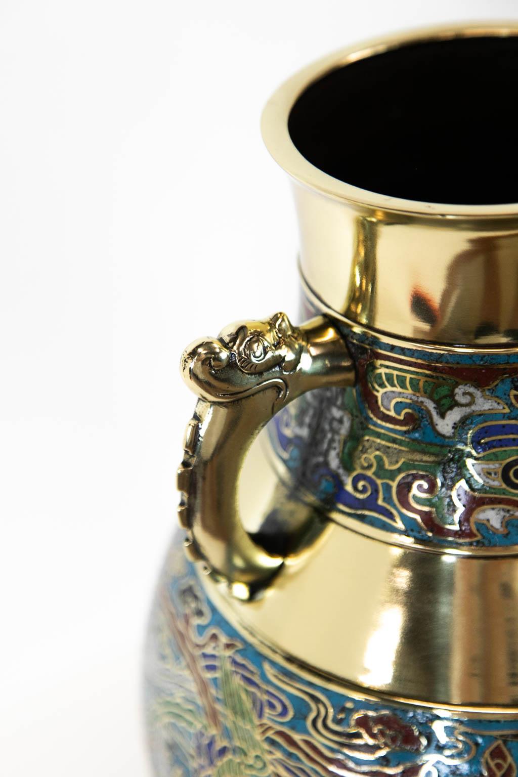 This Japanese brass vase has stylized dragon handles and polychrome cloisons depicting birds, clouds, and leaves. It is polished and lacquered for ease of maintenance.