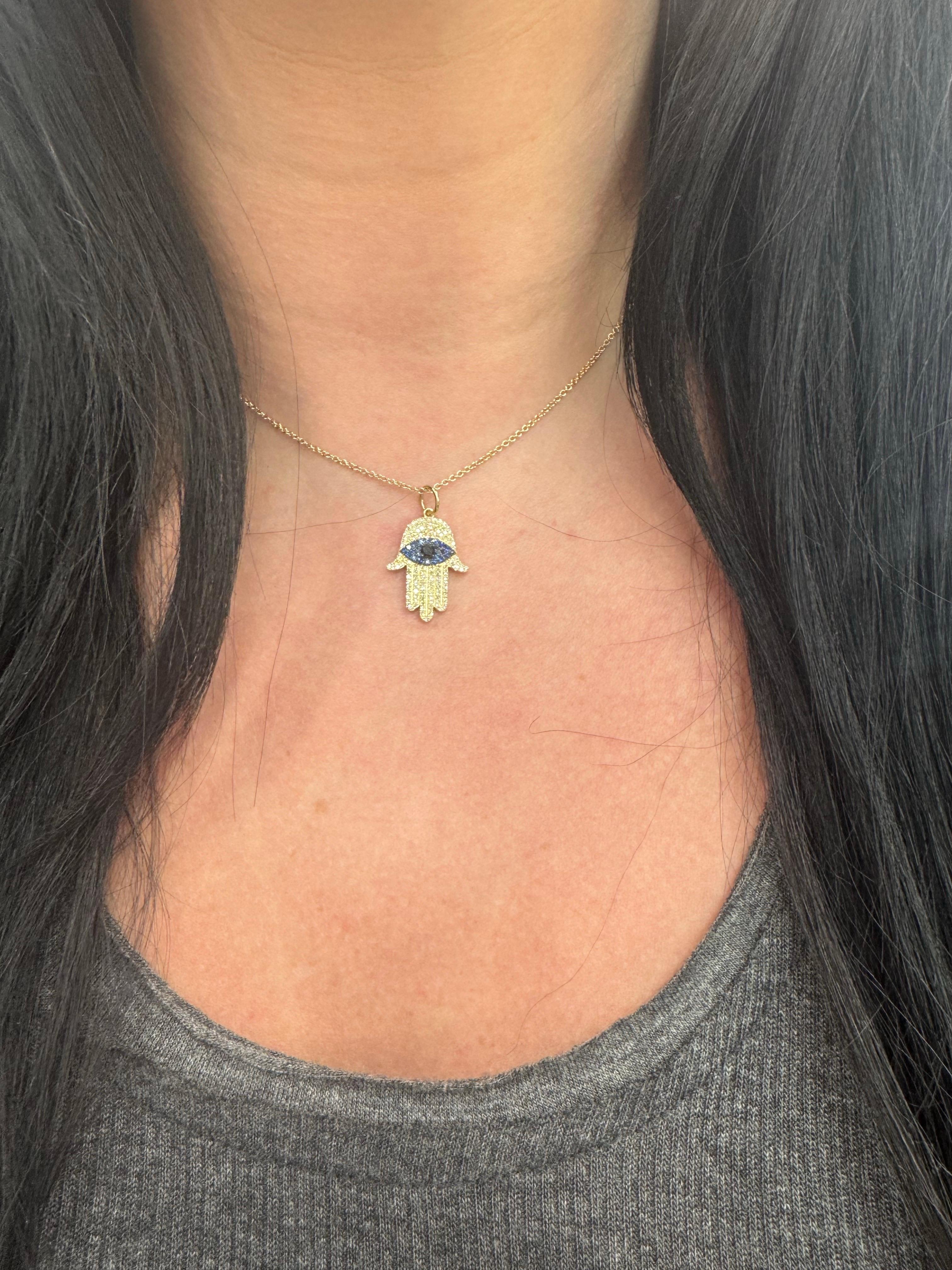 Pendentif Chamsa à breloque Œil maléfique incrusté de diamants ronds, 0,31 carats et de saphirs pesant 0,25 carats, réalisé en or jaune 14 carats. 

Ce prix s'applique uniquement au pendentif à breloques, pas au collier.

Construisez votre propre