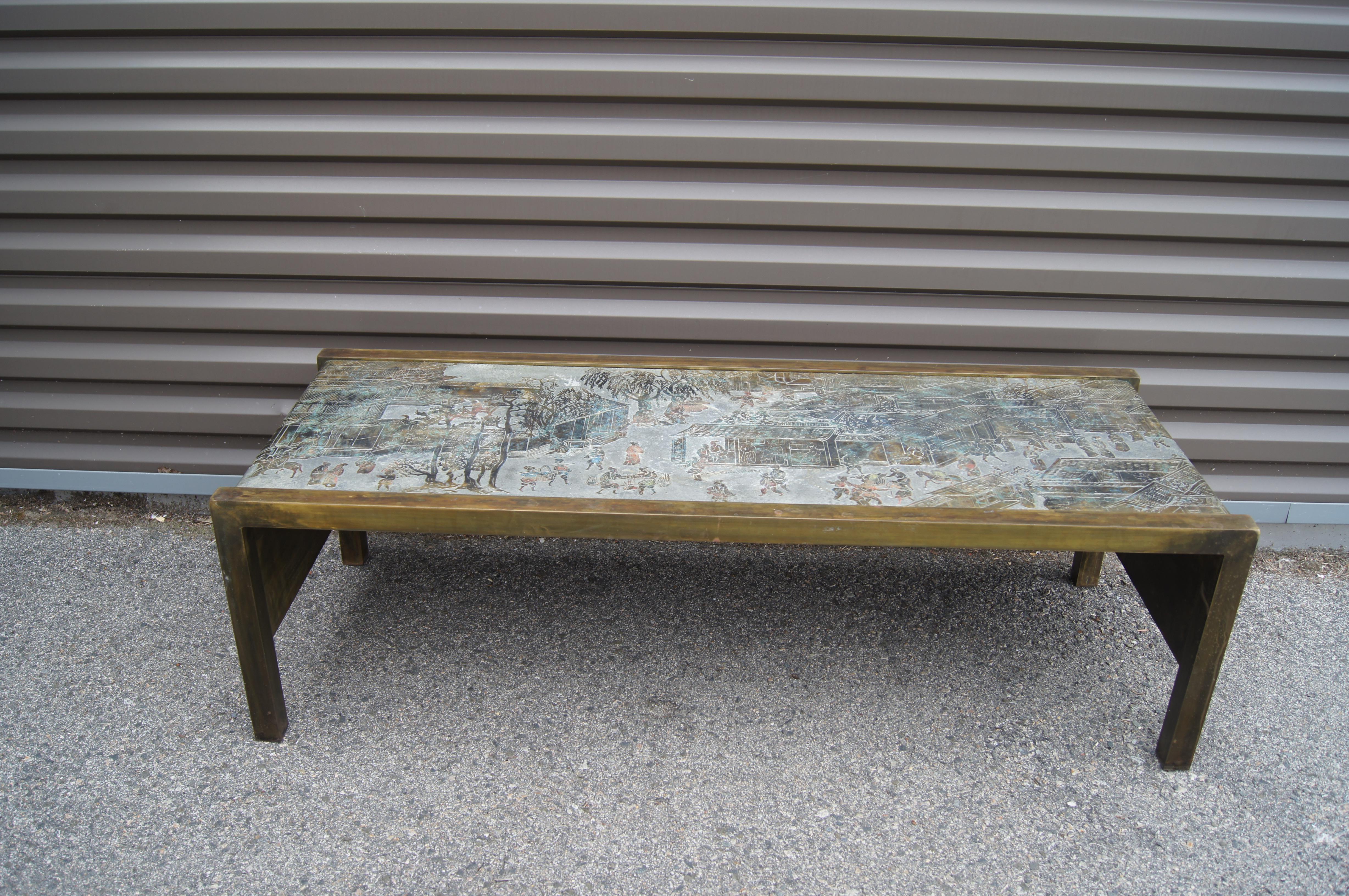 Philip and Kelvin LaVerne crafted the Chan coffee table by acid-etching bronze, pewter, and colored enamel. Depicting village activity, this hard-to-find iteration of the patinated table features a waterfall edge with the colorful scene flowing