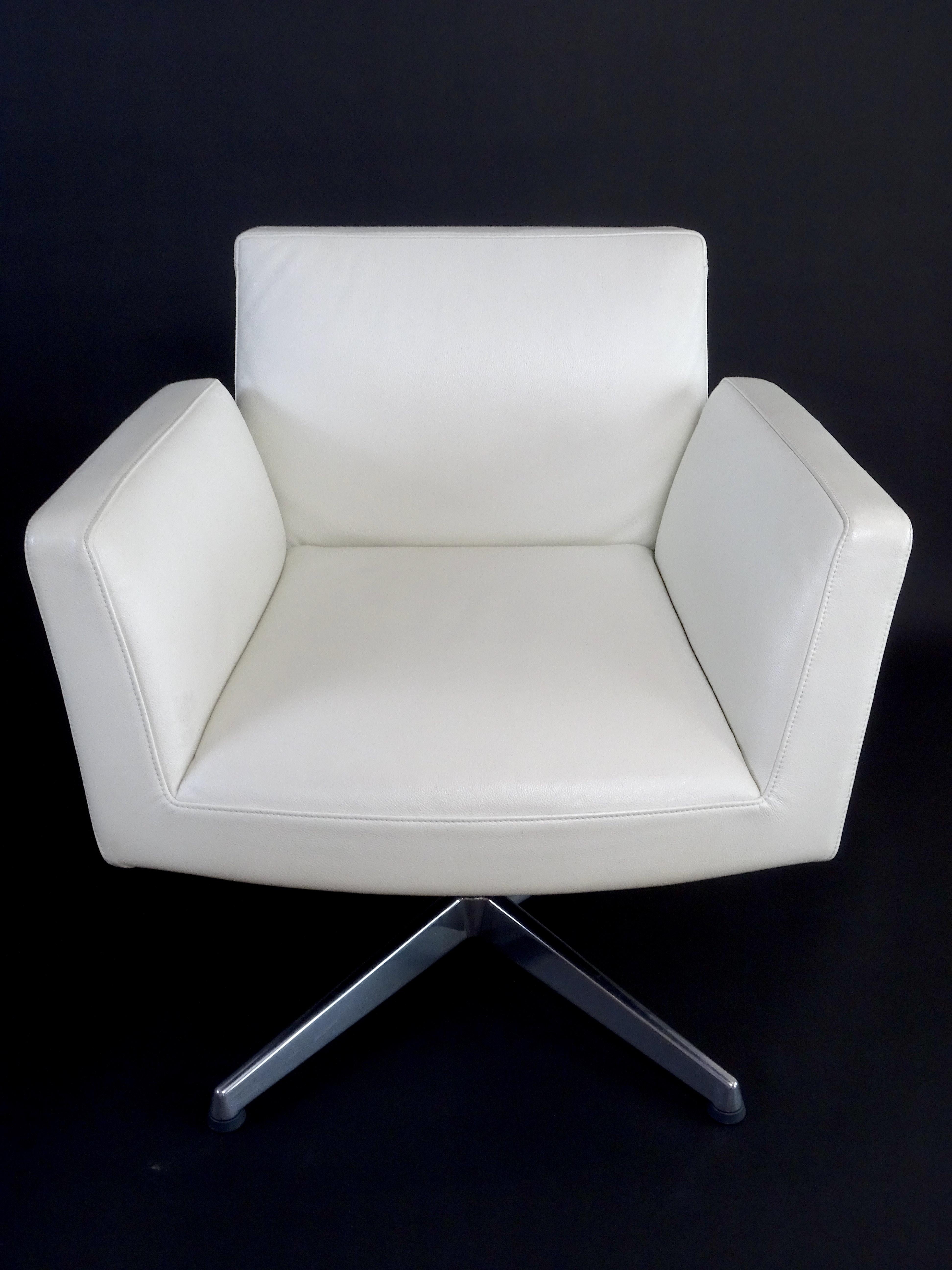 Set of two of office armchairs with armrests and 4 spokes, the upholstery is in white Poltrona Frau leather while the base is made of polished aluminium. 

There is a swivel mechanism and an internal bearing that guarantees the return to the
