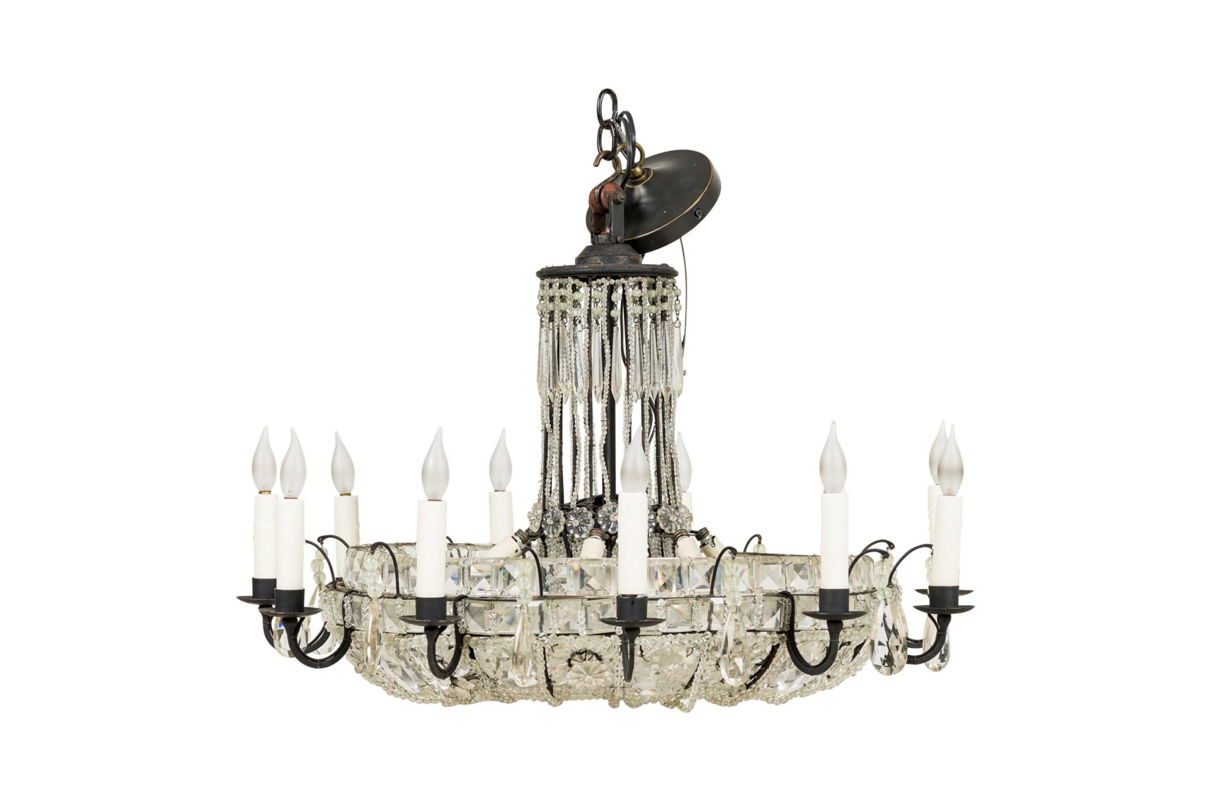 Lampadario rotondo francese del Mid-Century con 12 bracci a voluta in metallo scuro che circondano pannelli di vetro con perline e un centro rialzato con fili di perline.

Condit: (Mancano due piccole perle di cristallo)