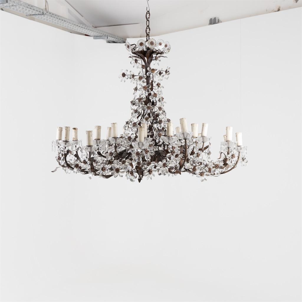 Large chandelier with stylized brass leaf decor and glass flowers.