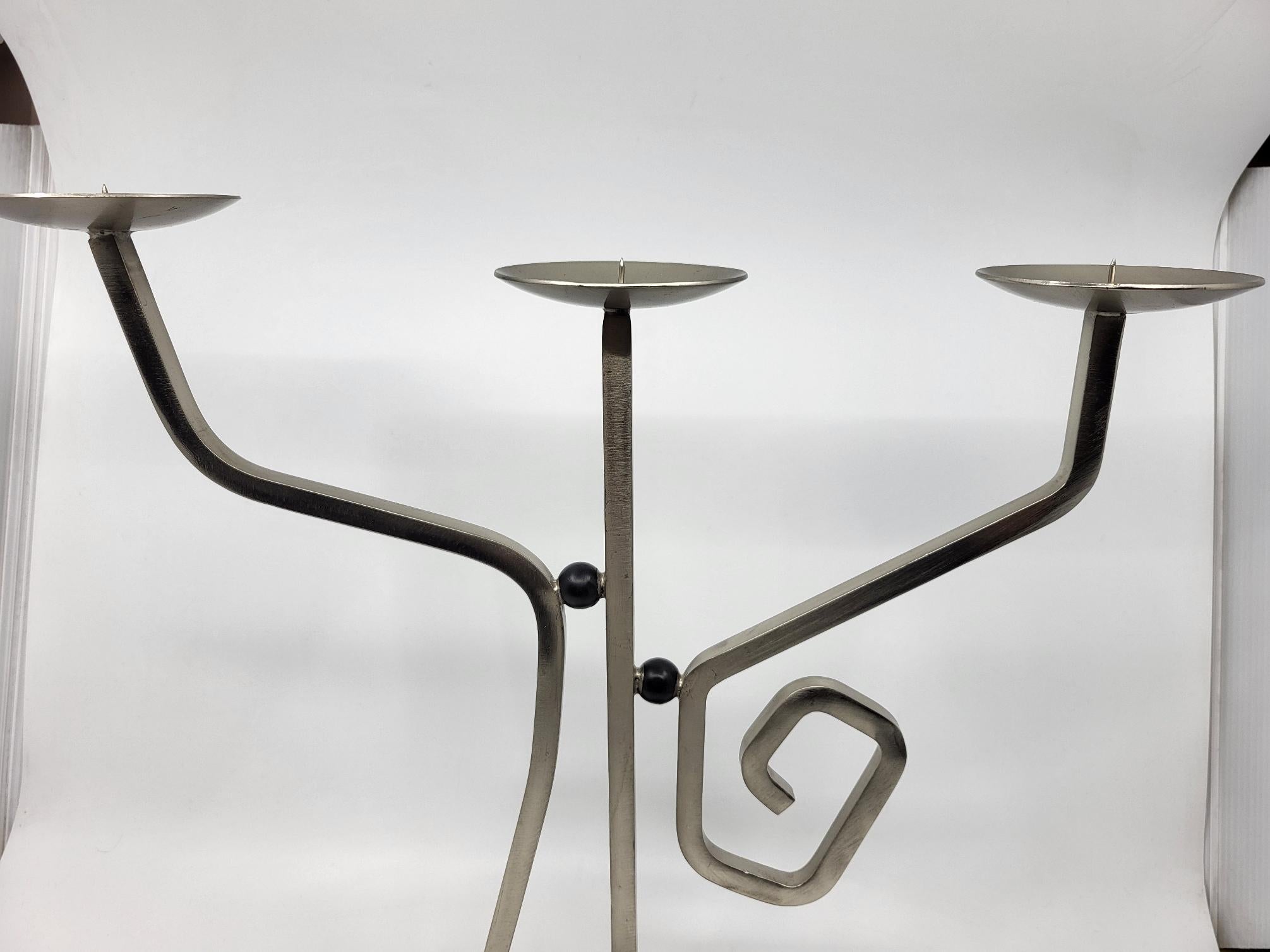 La collezione esclusiva di Garance Vallée in collaborazione con Monoprix presenta un magnifico lampadario a tre bracci, che unisce armoniosamente il legno e il metallo. Questa opera emblematica testimonia l'approccio artistico di Vallée, che naviga