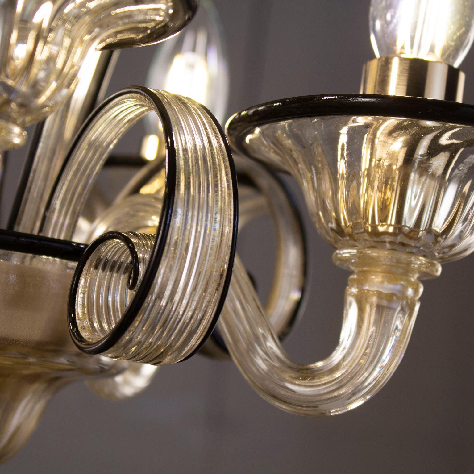 Capriccio chandelier, 5 lights, golden leaf artistic glass, with curly ornamental elements and black details by Multiforme.
Inspired by the Classic Venetian tradition it is characterised by a central column where many blown glass “pastoral” elements
