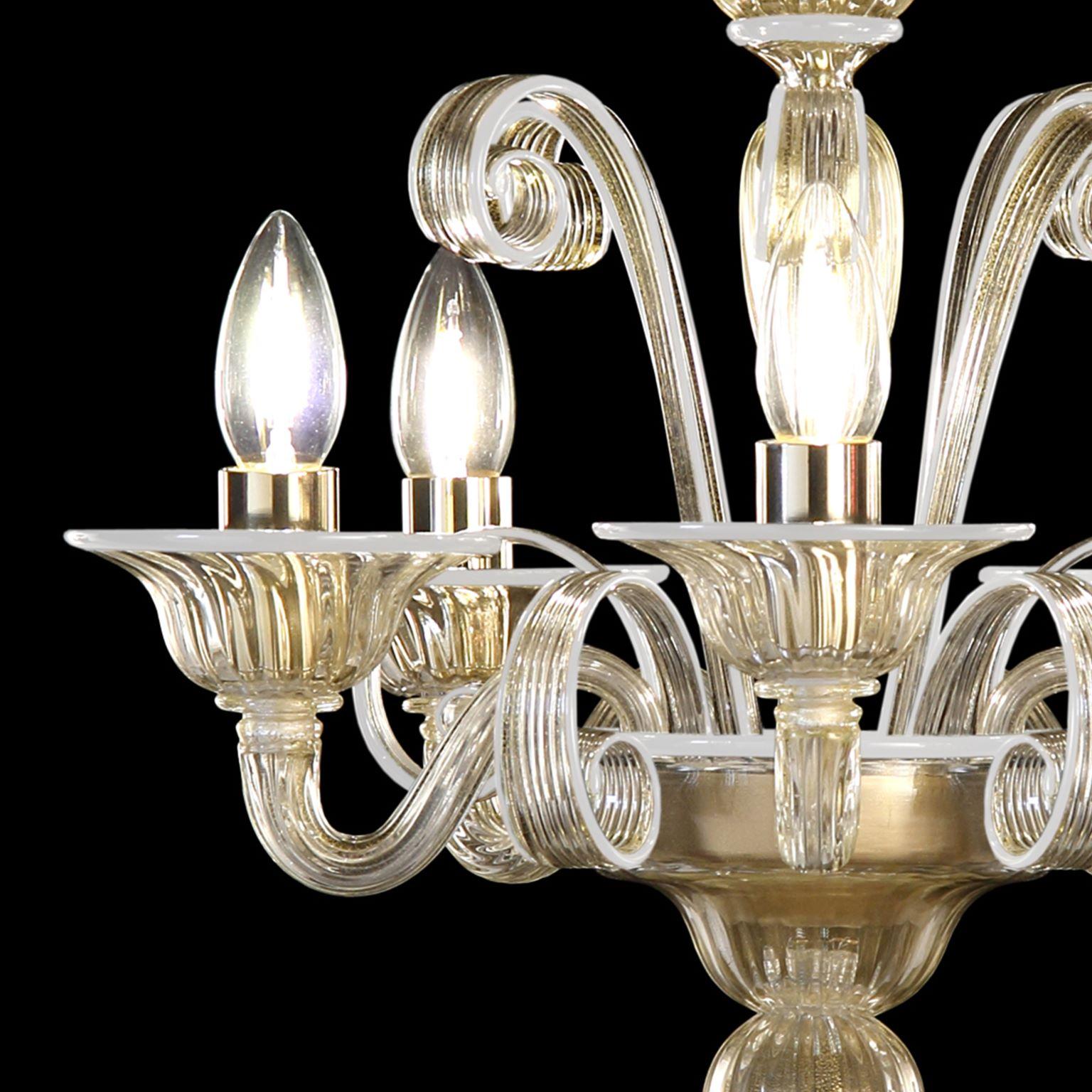 Capriccio chandelier, 5 lights, golden leaf artistic glass, with curly ornamental elements and white details by Multiforme.
Inspired by the Classic Venetian tradition it is characterised by a central column where many blown glass “pastoral” elements