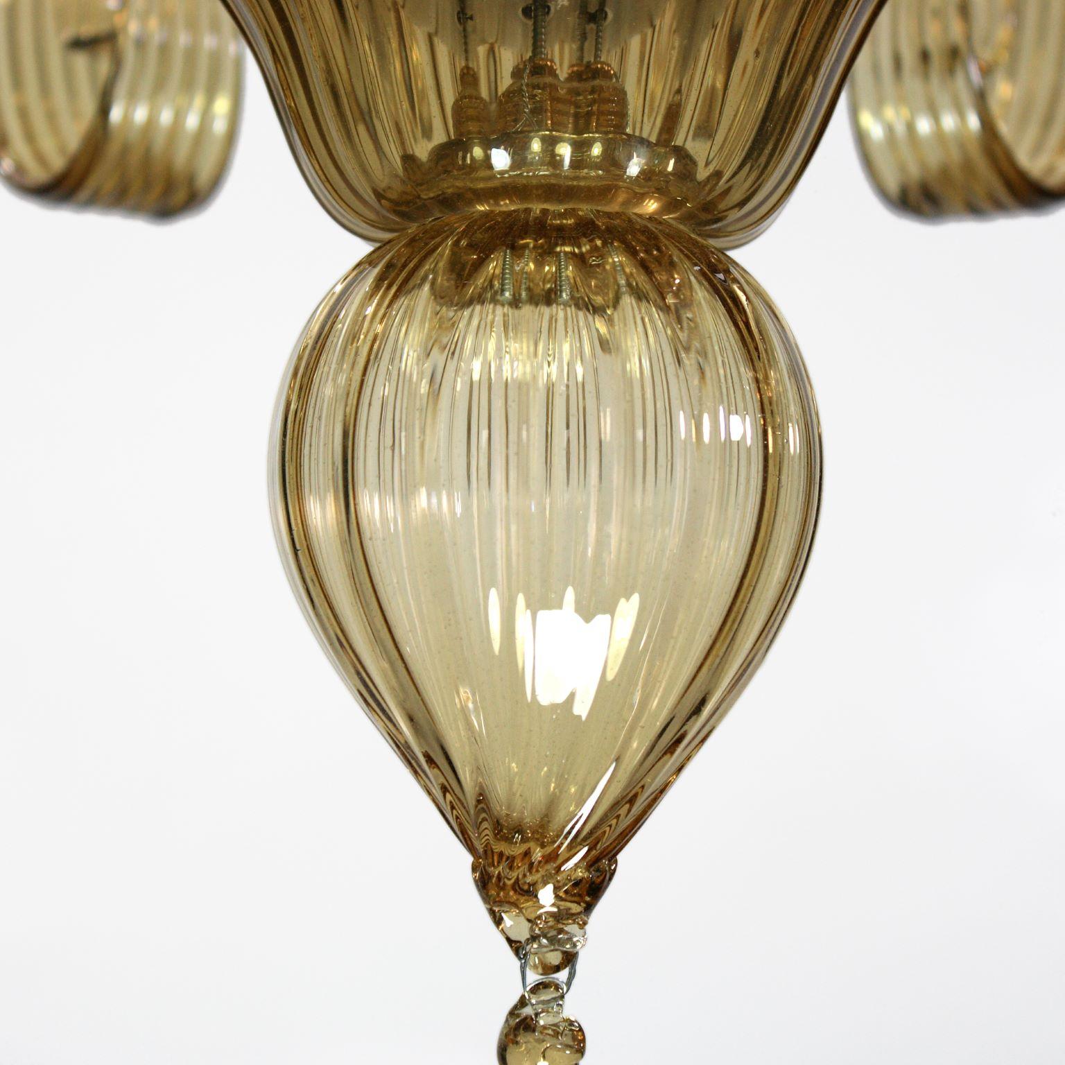 Capriccio de Multiforme est un lustre à 6 lumières, en verre artistique paille, avec des éléments ornementaux frisés.
Inspiré de la tradition classique vénitienne, il se caractérise par une colonne centrale où sont installés de nombreux éléments