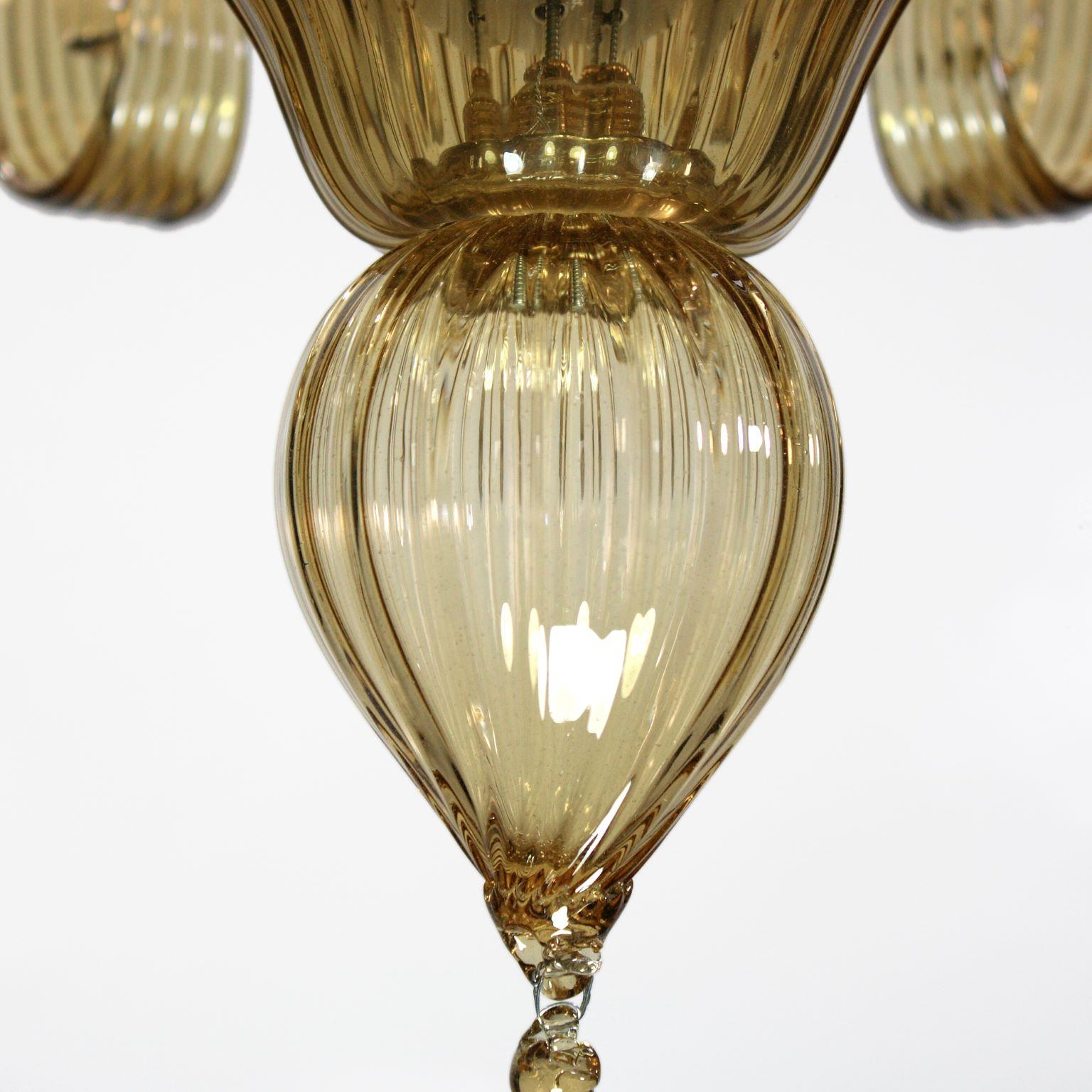 Capriccio di Multiforme è un lampadario a 6 luci, in vetro artistico paglierino, con elementi ornamentali a ricciolo.
Ispirata alla tradizione classica veneziana, è caratterizzata da una colonna centrale in cui sono installati molti elementi