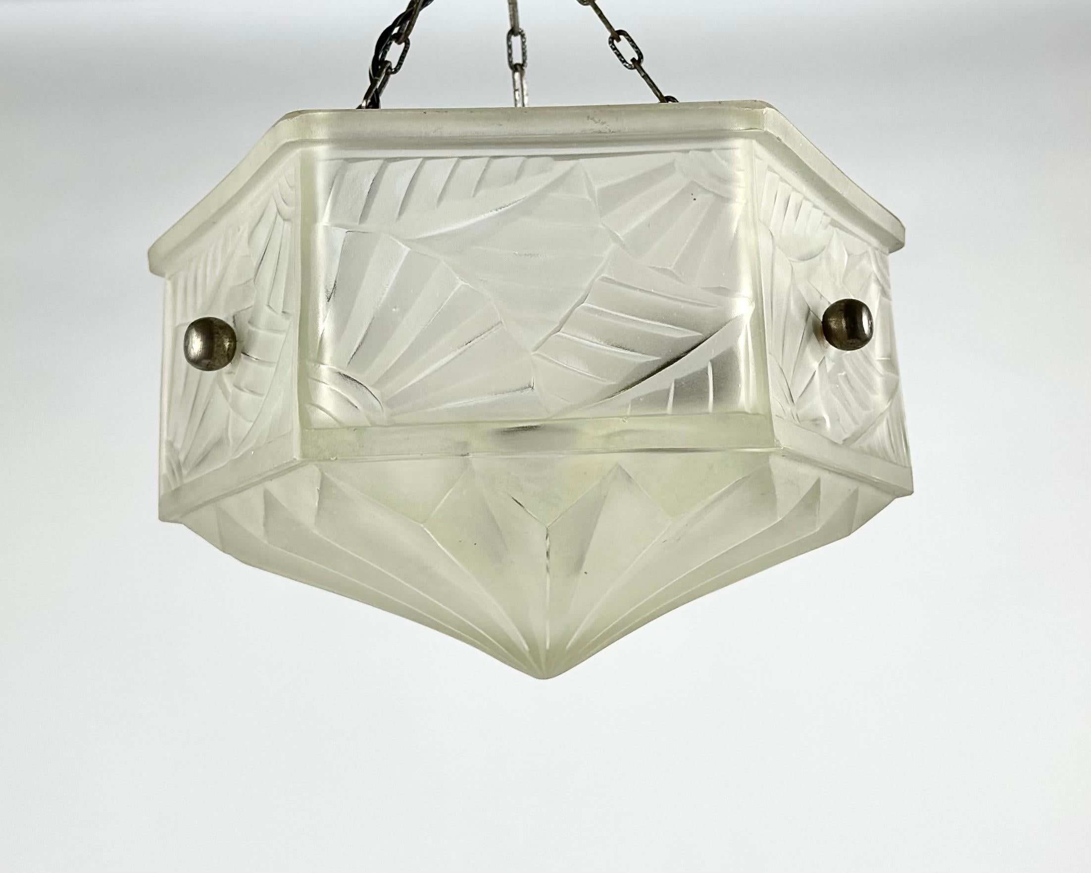 Art Deco pendant / chandelier from France. Period 1930 hand Molded-pressed glass with geometric decoration and stylized leaves.

Brass frame with three branches attached to the basin by three hanging points.

When the light pours through, the glass