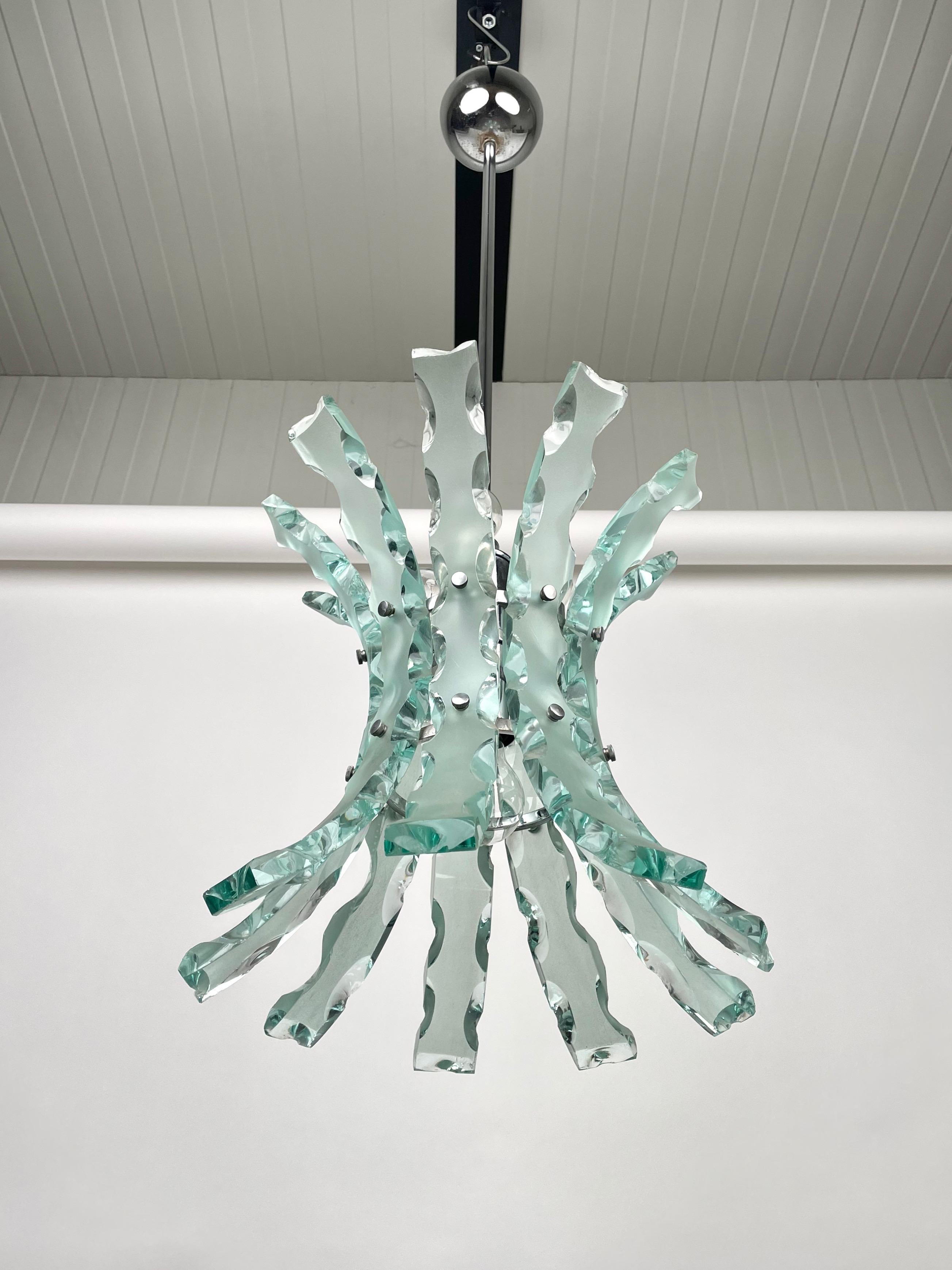 Curved Art glass and steel chandelier pendant by O4 (Zero Quattro) edited by Fontana Arte, Milano, Italy in the 1970s. The chandelier is composed of 9 glass and features 4 lights, three in the upper part and one on the bottom. Zero Quattro was a